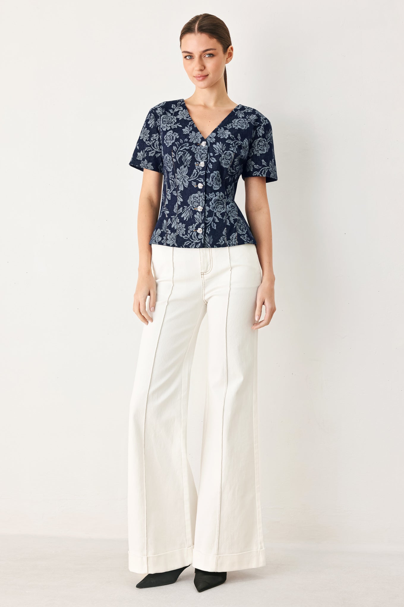 Woman wearing a denim woven jacquard top with V neckline, short sleeve, front button down and peplum | FREEMARKET