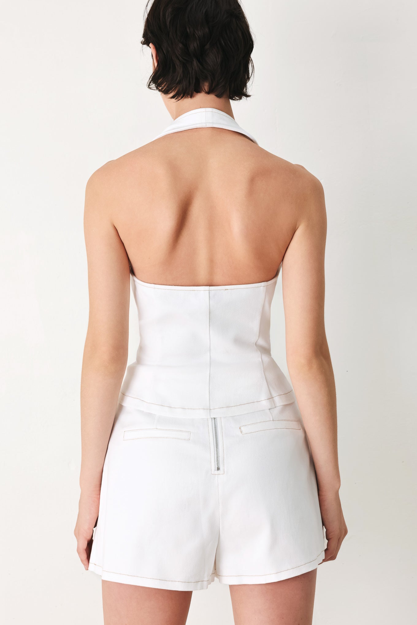 Woman wearing a white sleeveless halter vest and skort set | FREEMARKET
