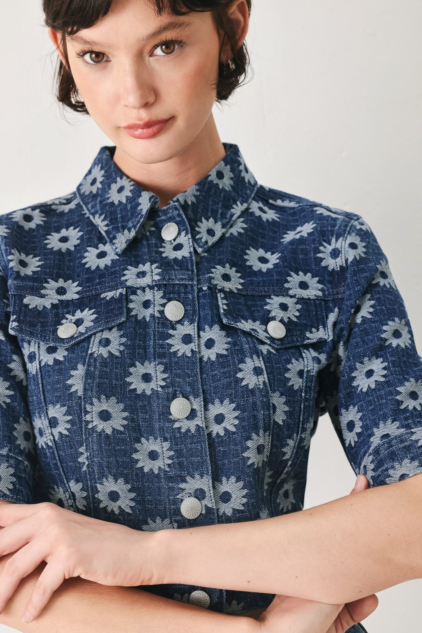 Woman wearing a blue denim floral patterned jacquard crop jacket featuring collar, elbow sleeve and front button closure | FREEMARKET