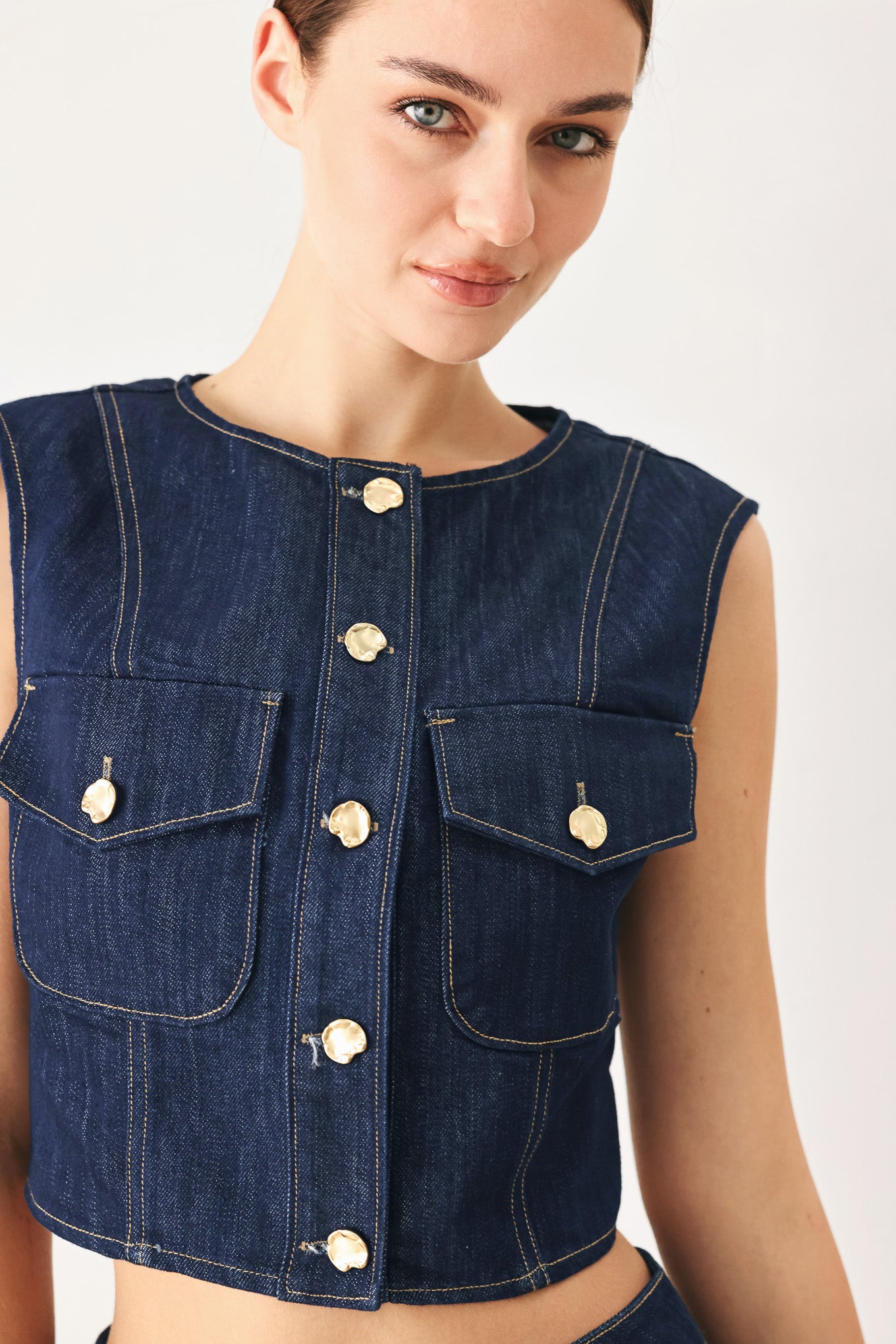 Woman wearing a denim denim crop vest with front button closure | FREEMARKET
