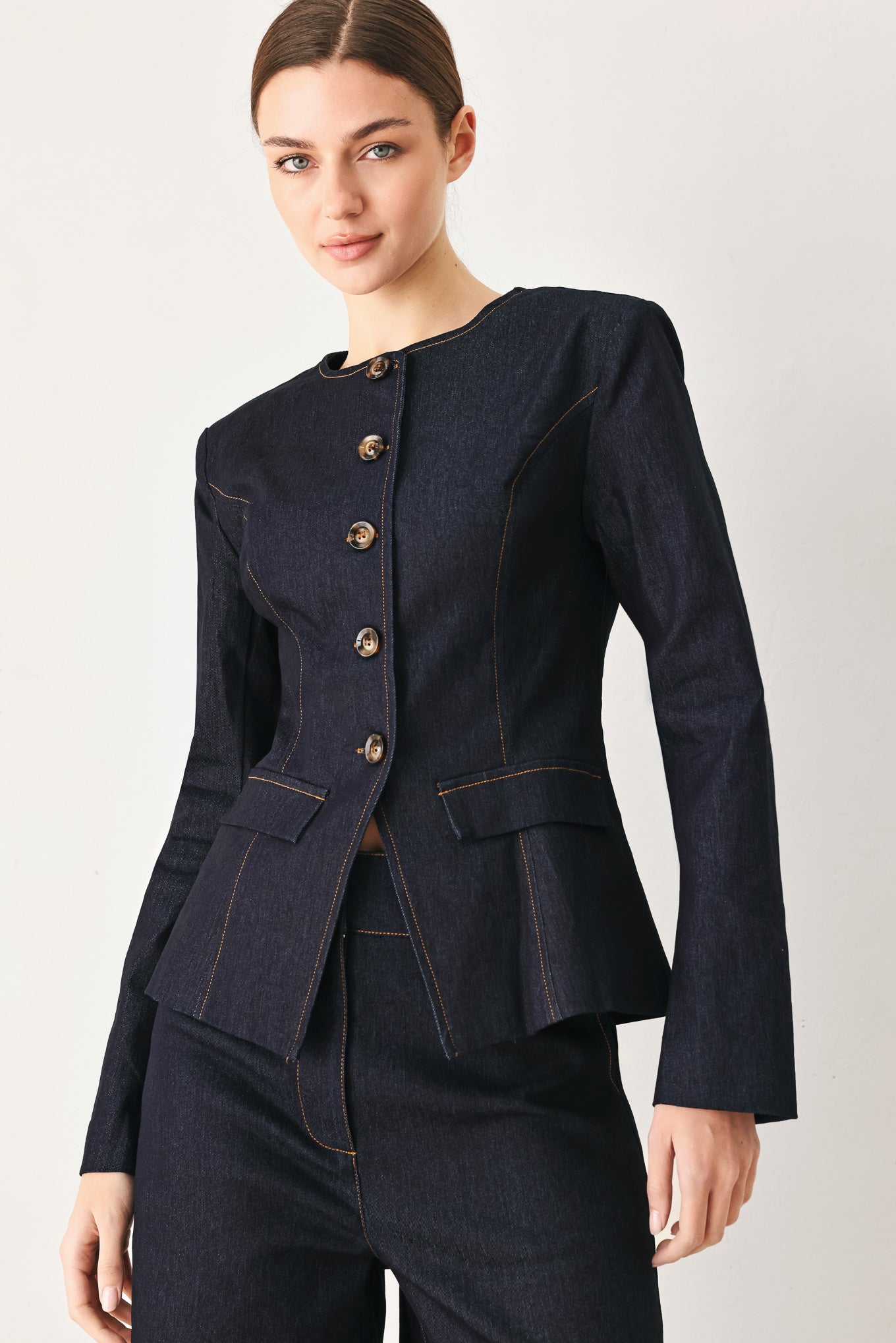 Woman wearing a dark denim jacket with round neckline, long sleeve and front button closure | FREEMARKET