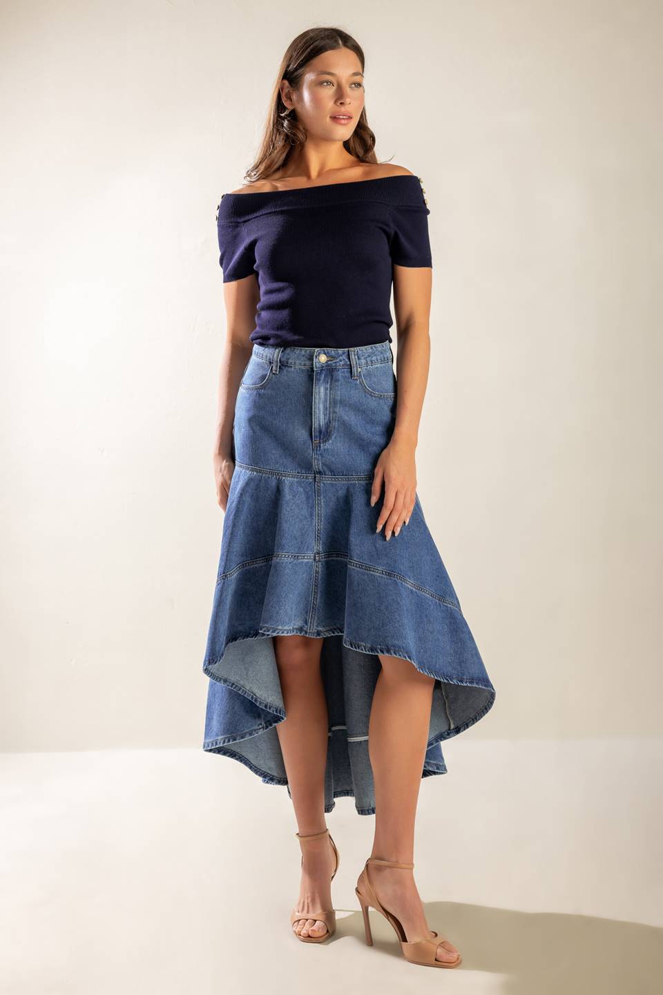 A washed denim skirt featuring front closure, side pockets, hi-lo hemline and back pockets