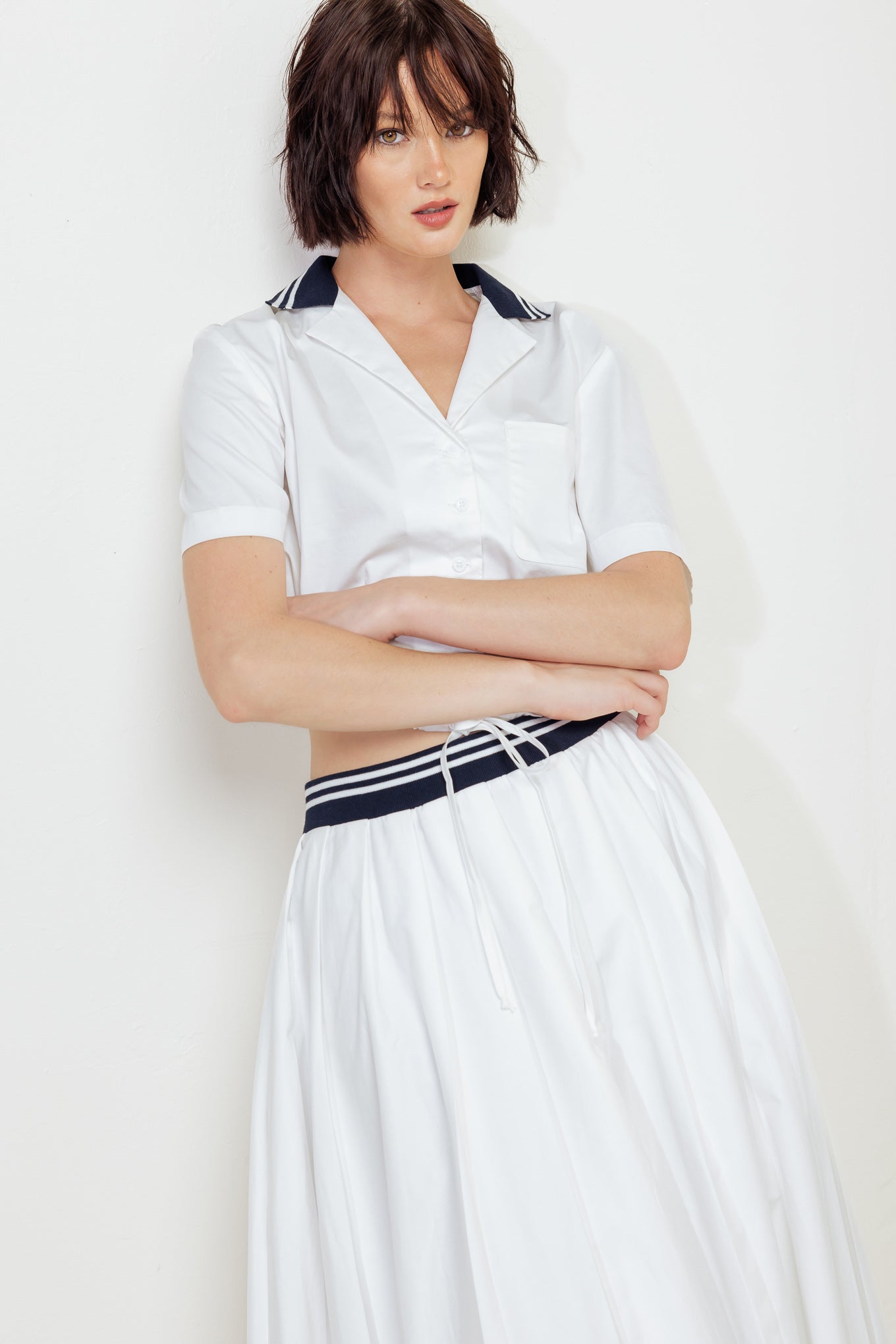 A solid woven midi skirt with contrasting waistband and side zipper closure.