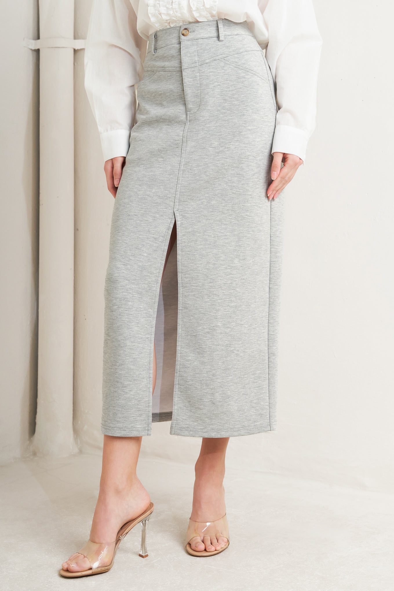 A solid knit skirt featuring pencil skirt, front closure, back pocket and front slit. Flying Tomato