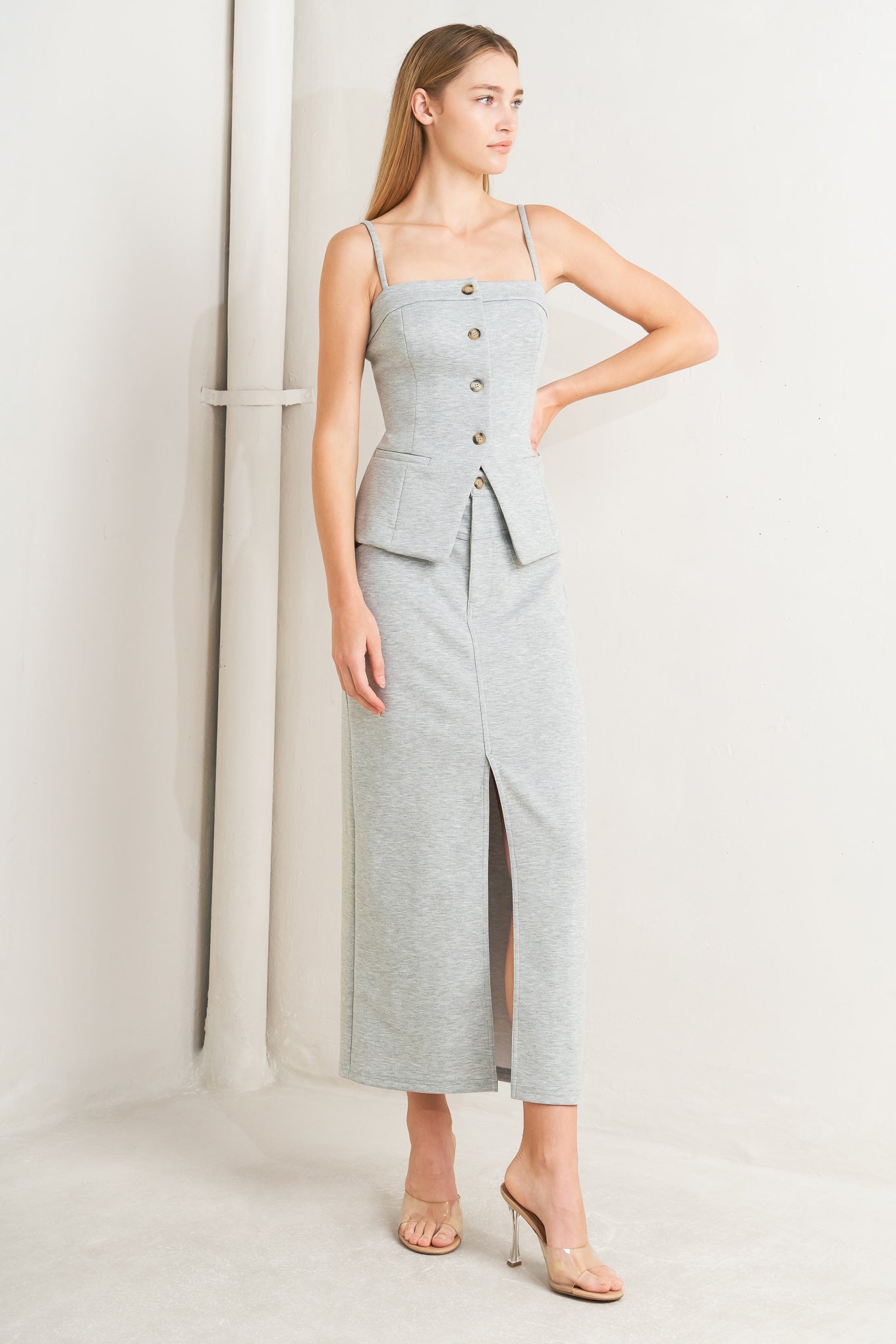 A solid knit skirt featuring pencil skirt, front closure, back pocket and front slit. Flying Tomato