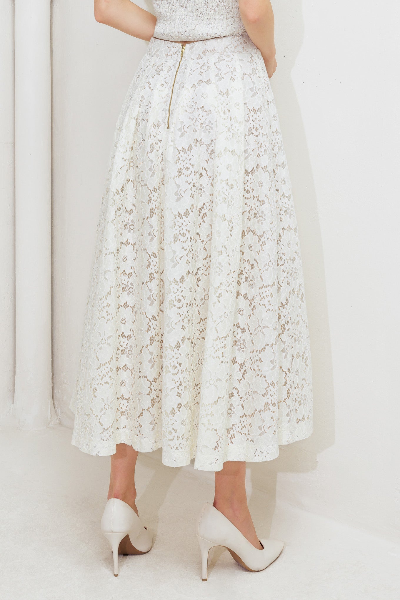 A woven lace midi skirt with back zipper closure.