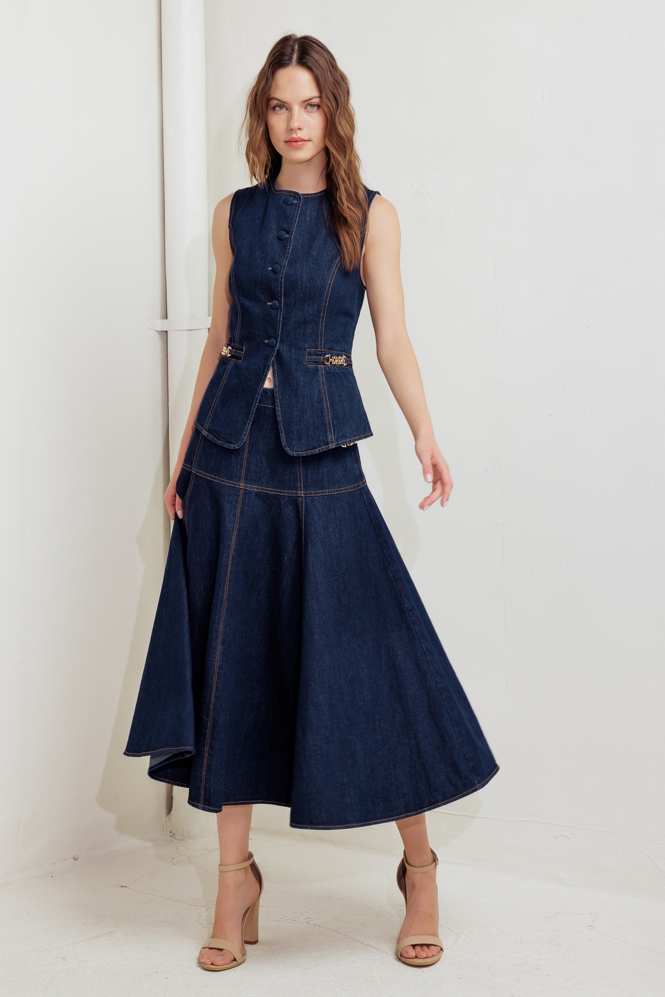 A denim skirt featuring side hardware trim, circle skirt and back zipper closure.