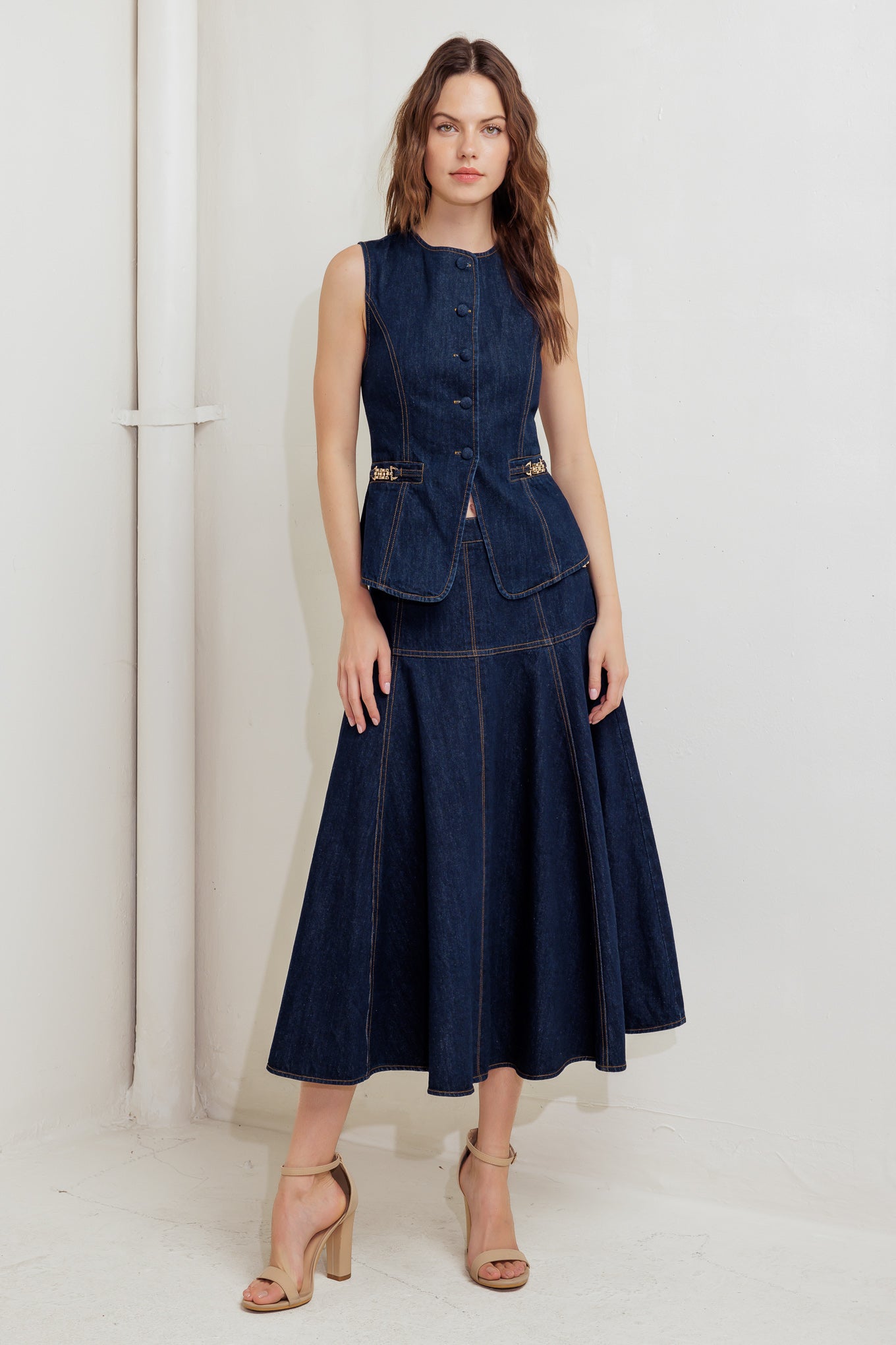 A denim skirt featuring side hardware trim, circle skirt and back zipper closure.