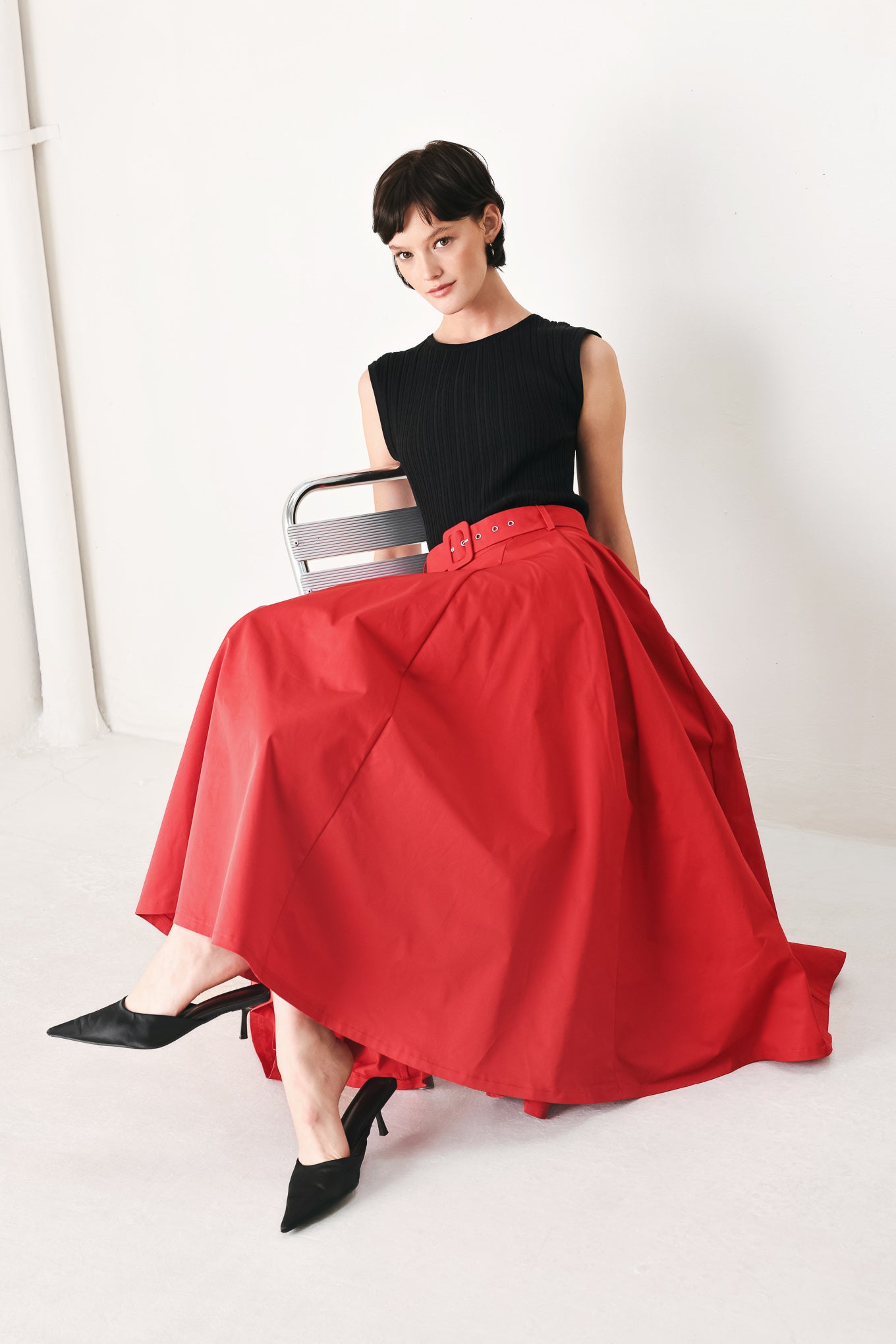Woman wearing a red full midi skirt featuring self belt and side zipper closure | FREEMARKET