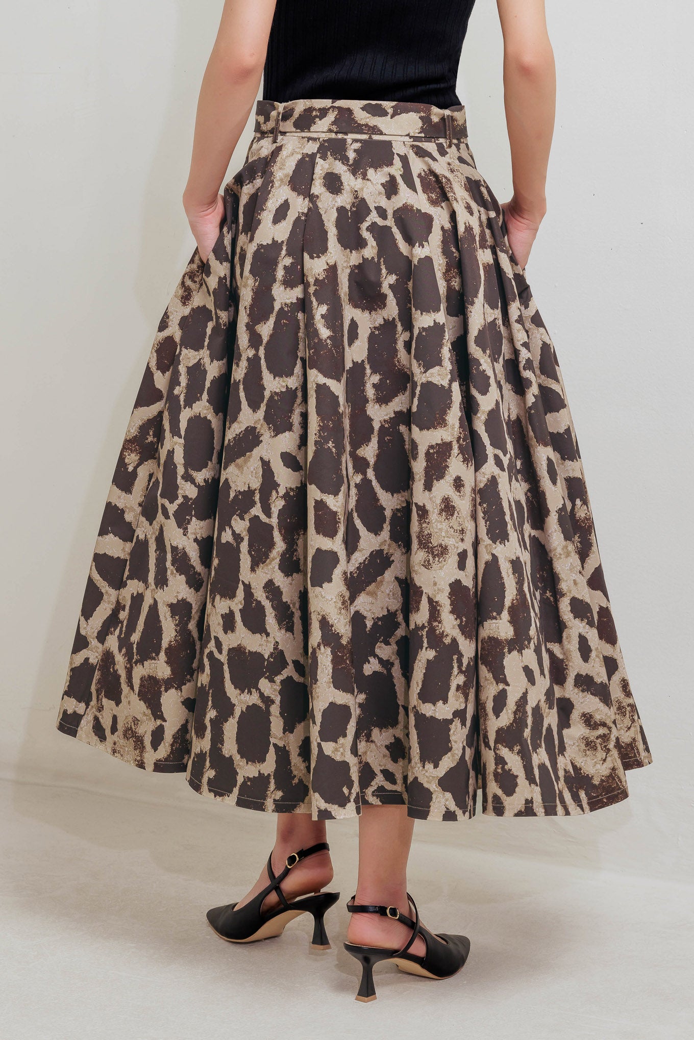 A printed woven full midi skirt featuring self belt, side pockets and zipper closure