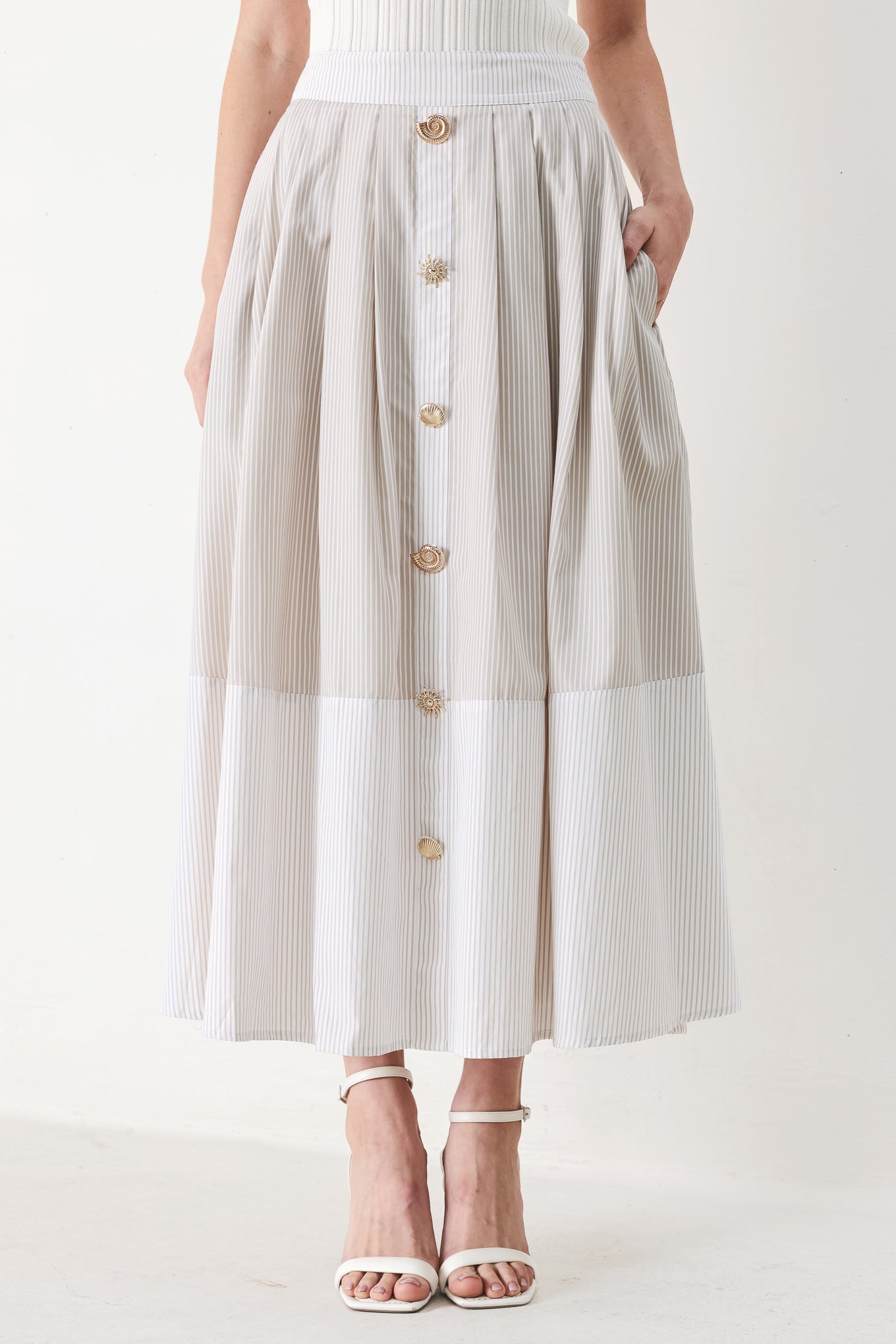 Woman wearing a taupe and white striped woven midi skirt with front button detail, box pleats and back zipper closure | FREEMARKET