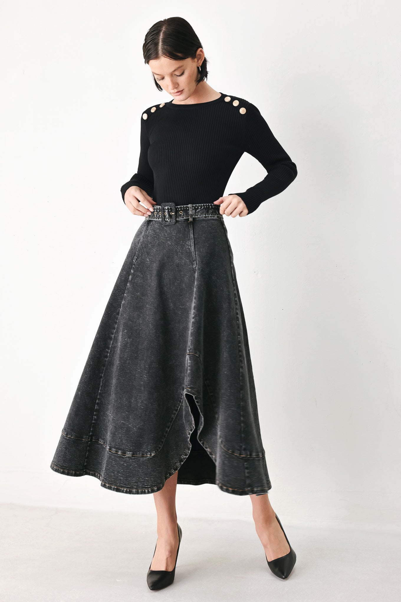 A model wearing a high-waisted, dark gray washed denim midi skirt with a decorative studded belt | FREEMARKET