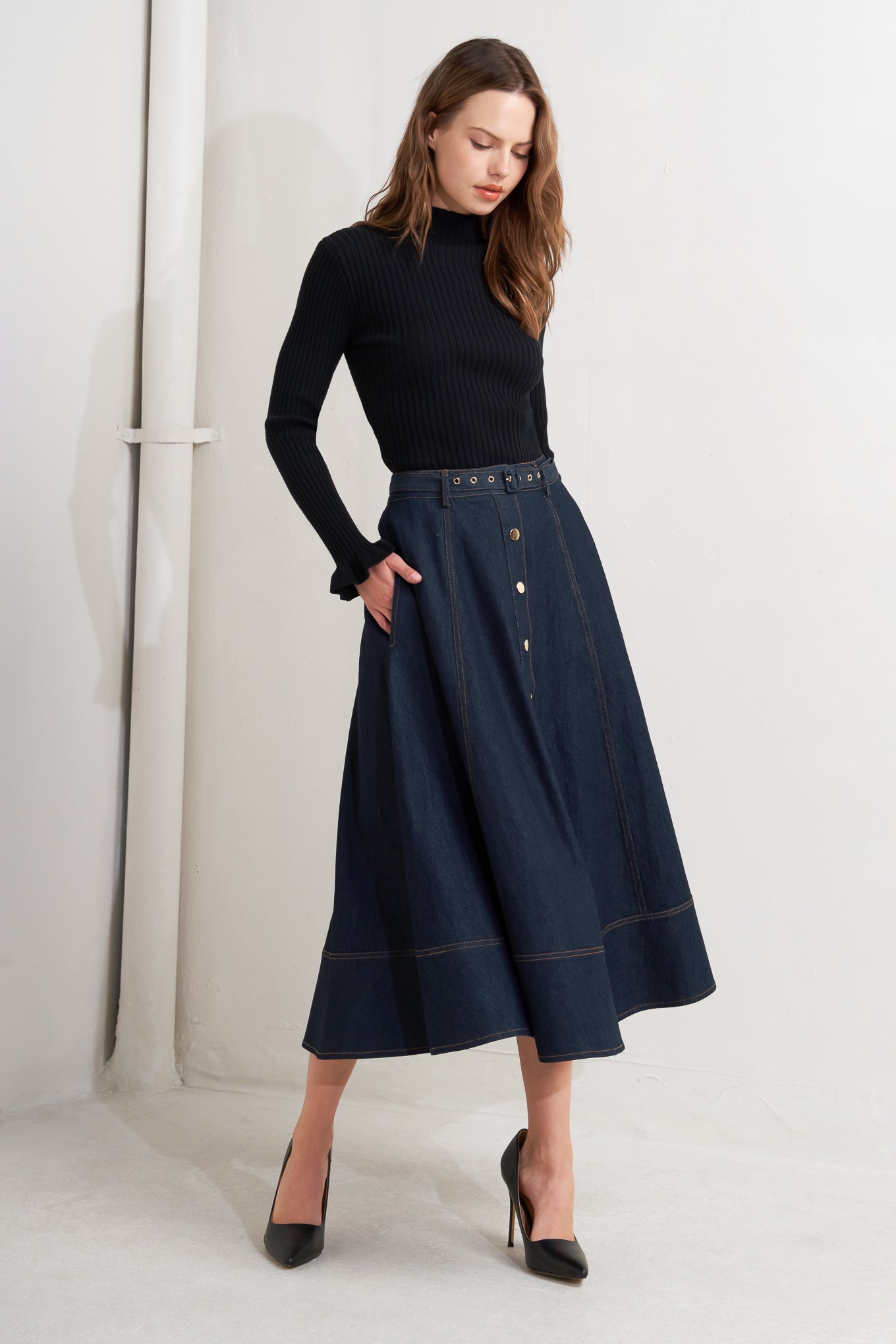 A denim circle skirt featuring self belt, front button down and wide hemline