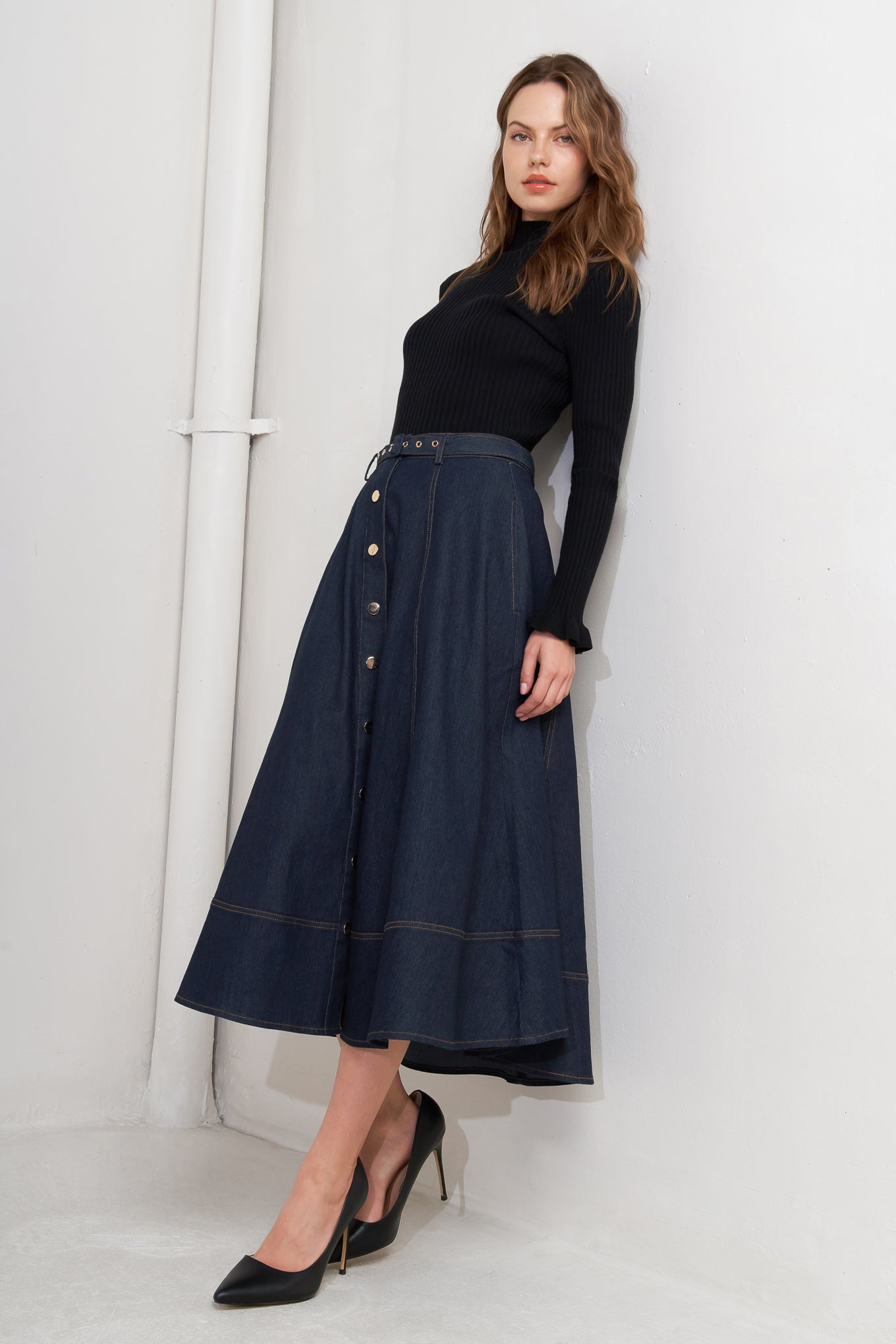 A denim circle skirt featuring self belt, front button down and wide hemline