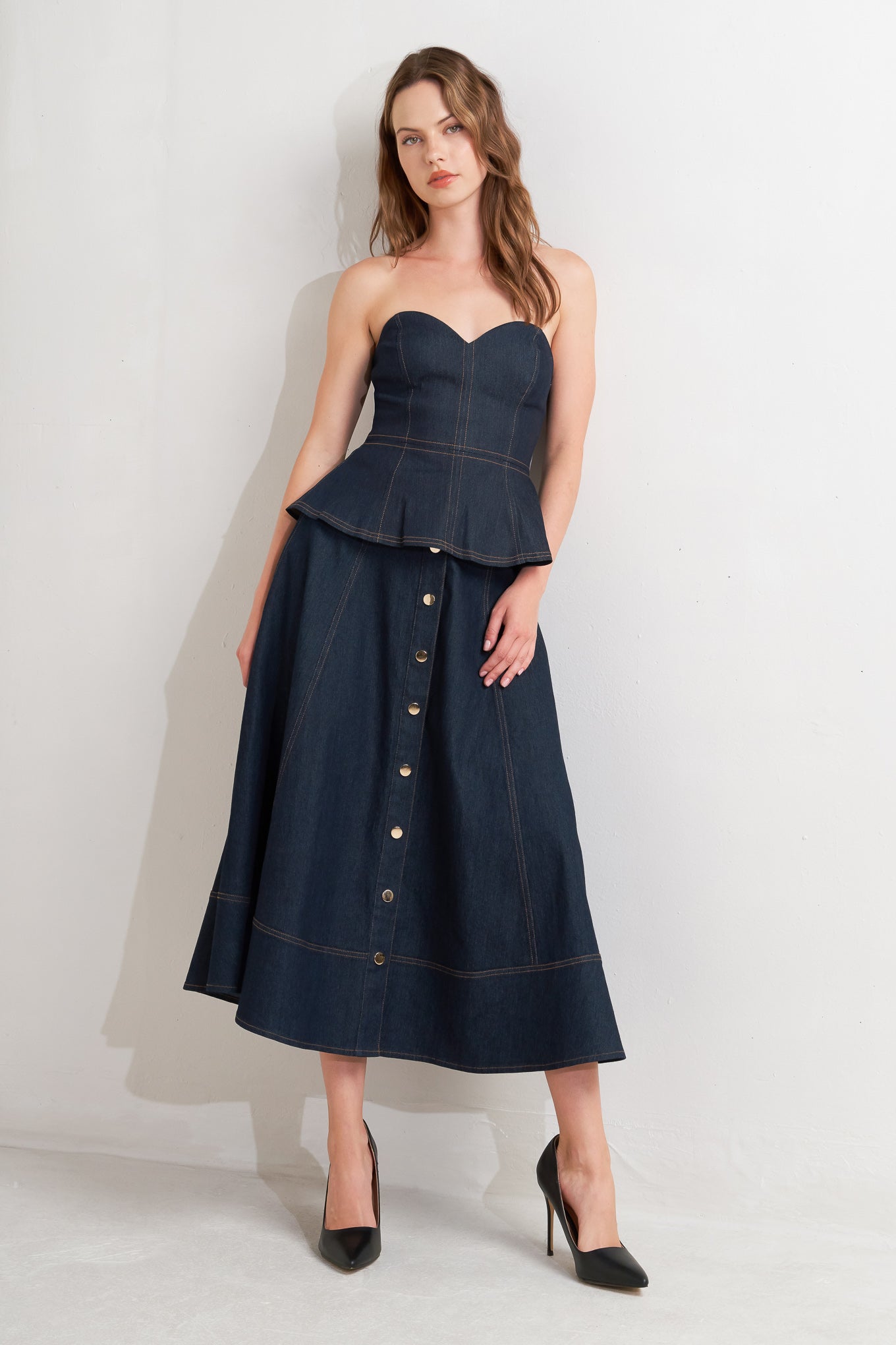 A denim circle skirt featuring self belt, front button down and wide hemline