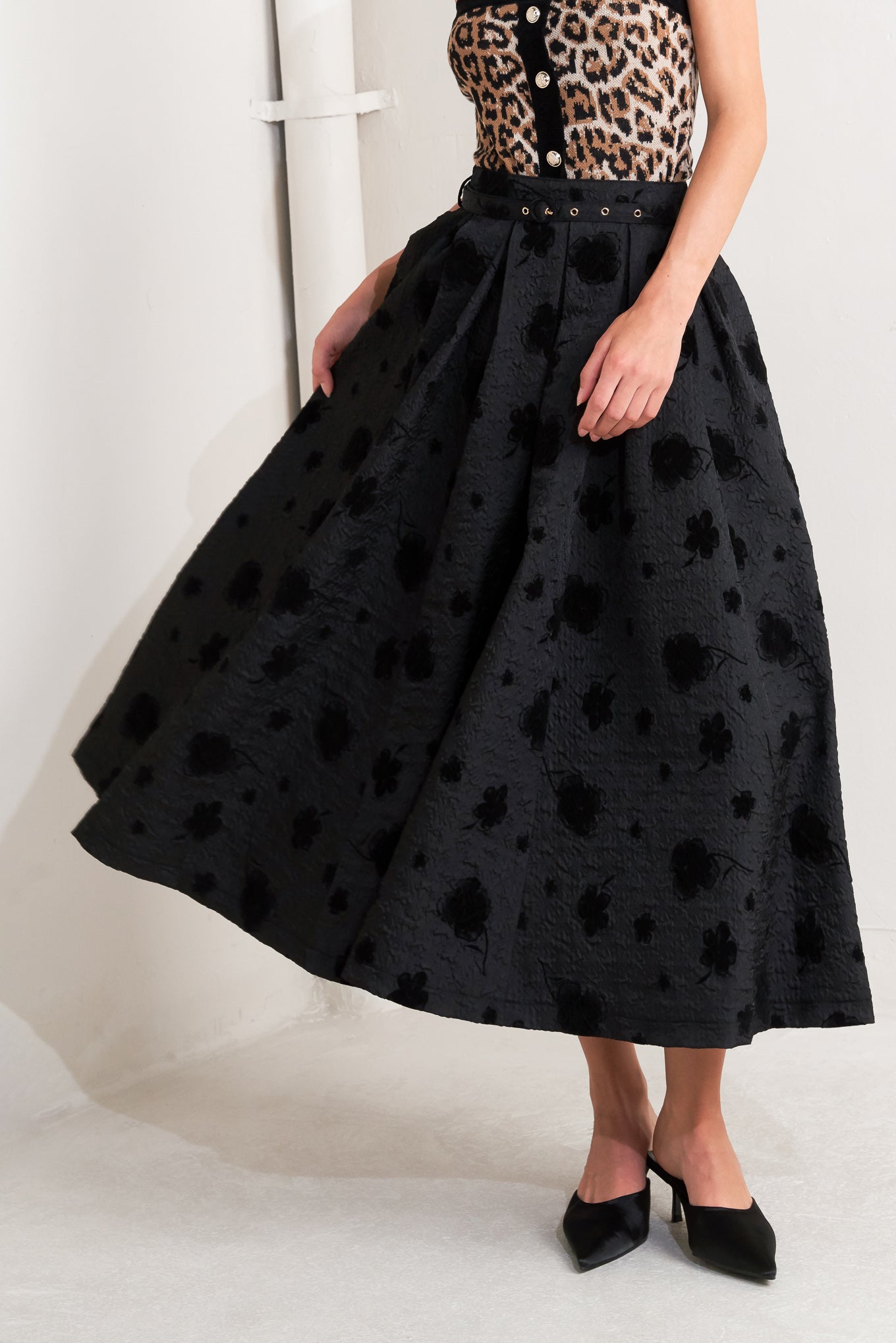 A textured woven full midi skirt with self belt and back zipper closure.