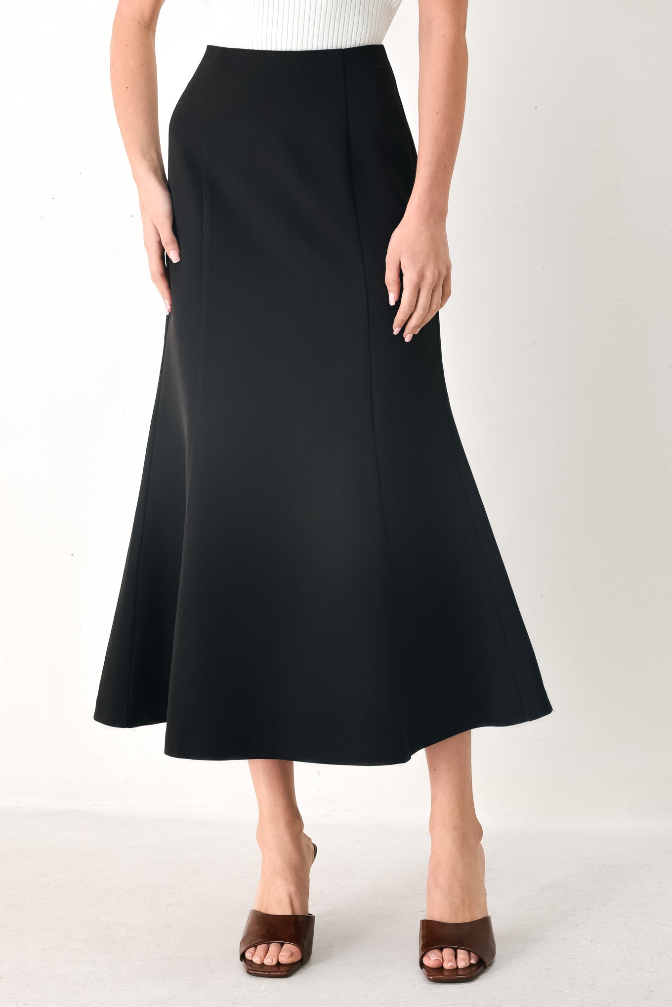 Woman wearing a black midi skirt with back zipper closure | FREEMARKET