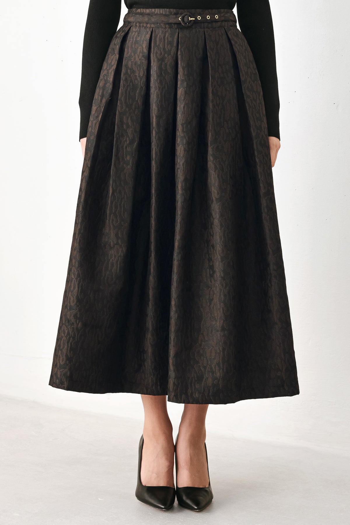 A high-waisted, pleated midi skirt in a dark brown and black jacquard leopard print pattern, styled with a matching belt | FREEMARKET
