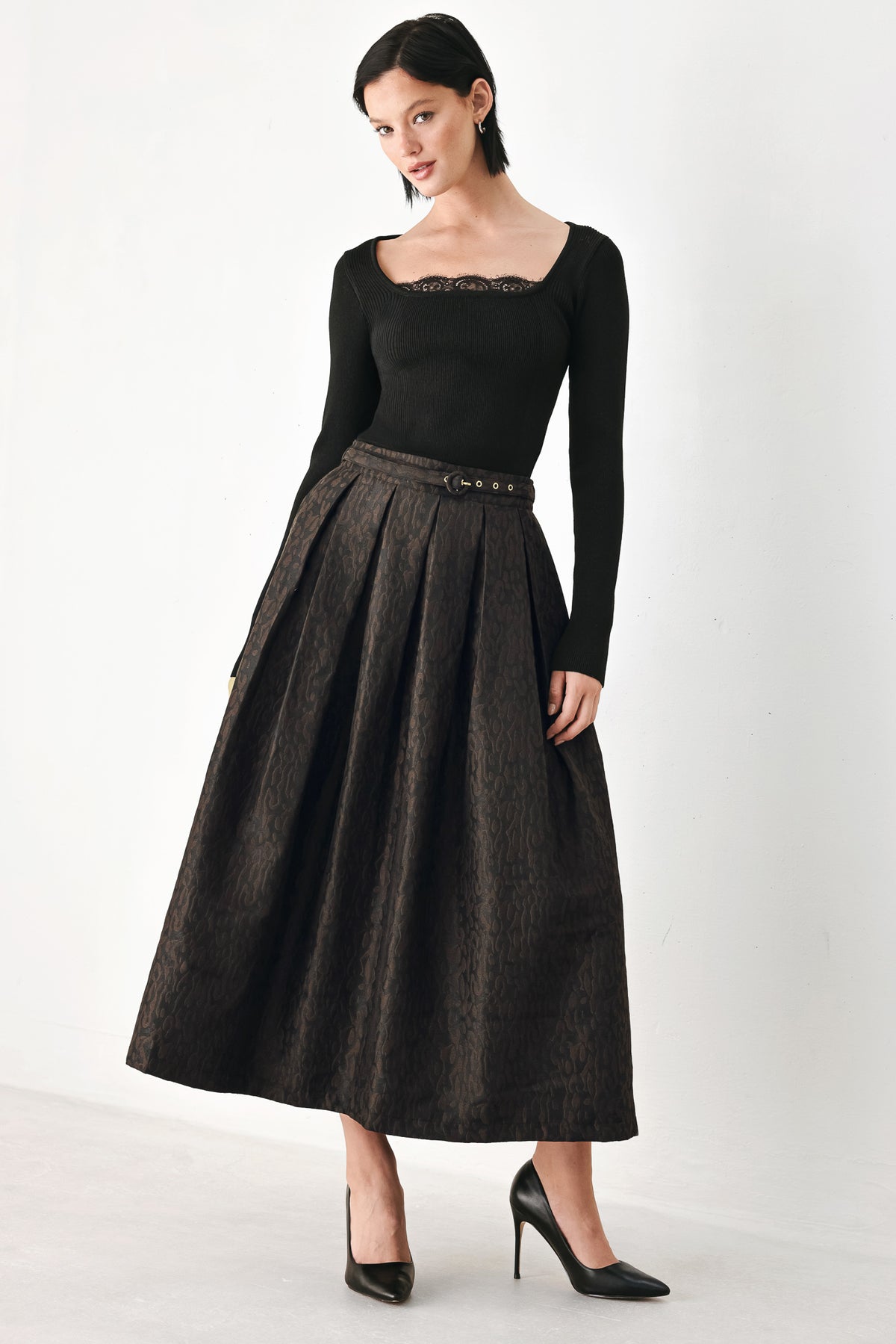 A high-waisted, pleated midi skirt in a dark brown and black jacquard leopard print pattern, styled with a matching belt | FREEMARKET