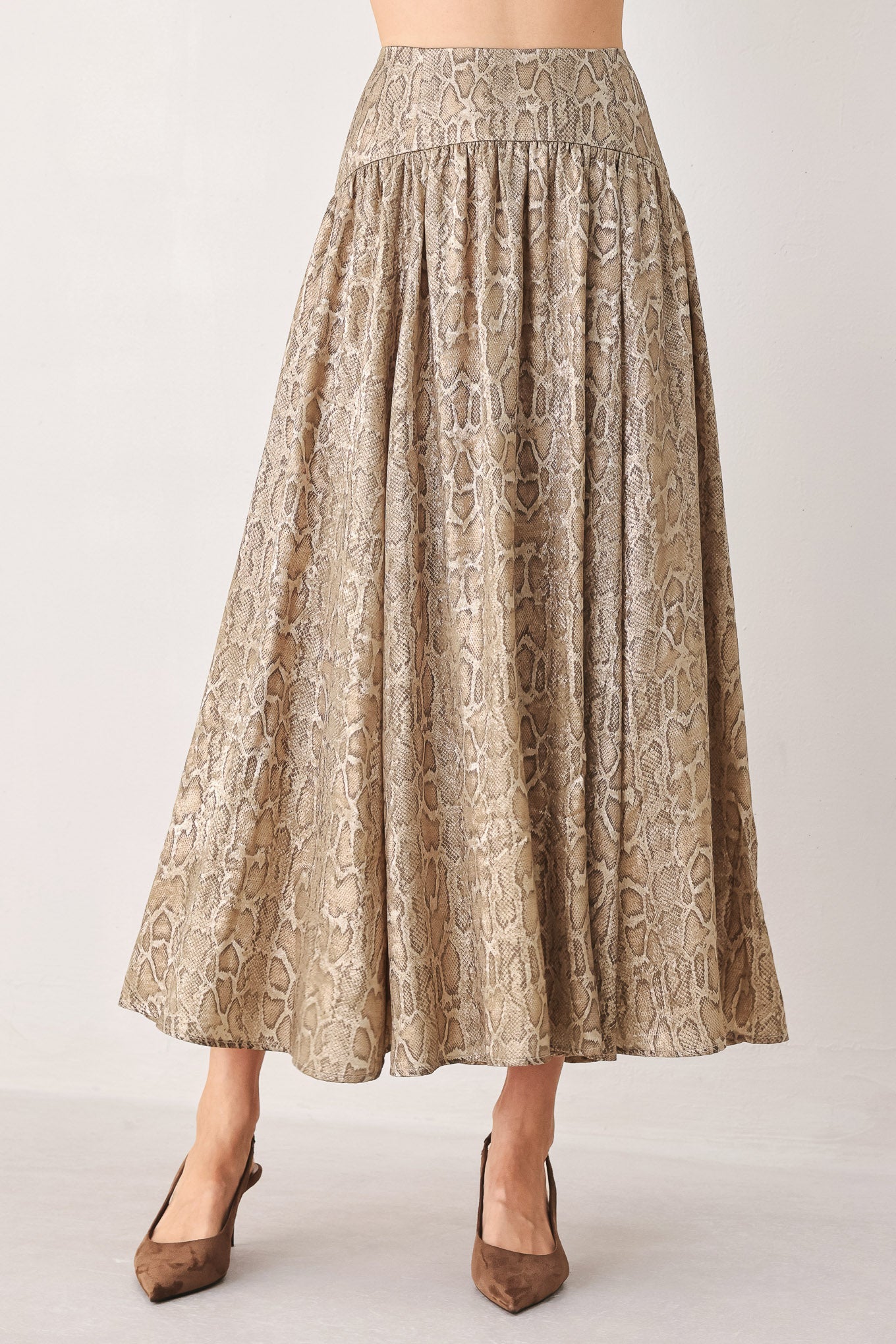 A woman wearing a high-waisted, A-line midi skirt with an all-over beige and brown snakeskin pattern | FREEMARKET