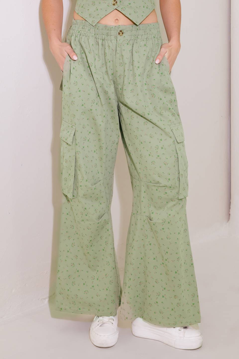 A printed woven pant featuring elasticized waist, front closure, cargo pockets and wide leg.