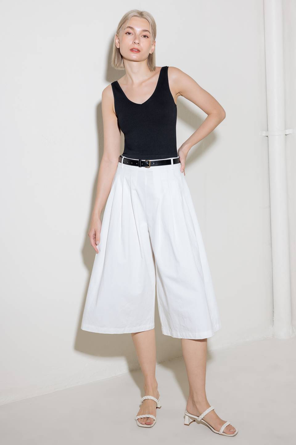 A solid woven culotte pant with front pleat, belt and side zipper closure.