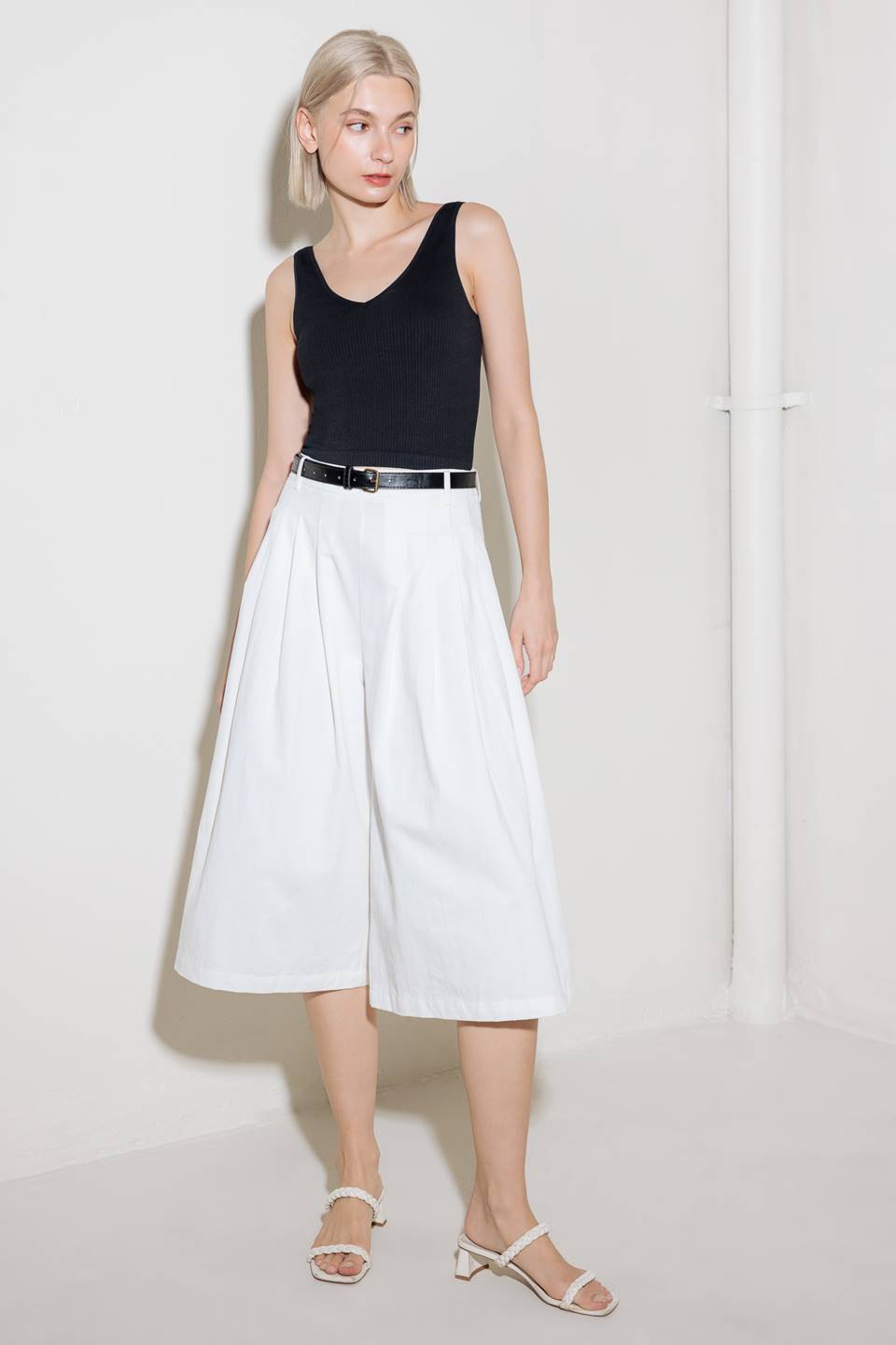 A solid woven culotte pant with front pleat, belt and side zipper closure.