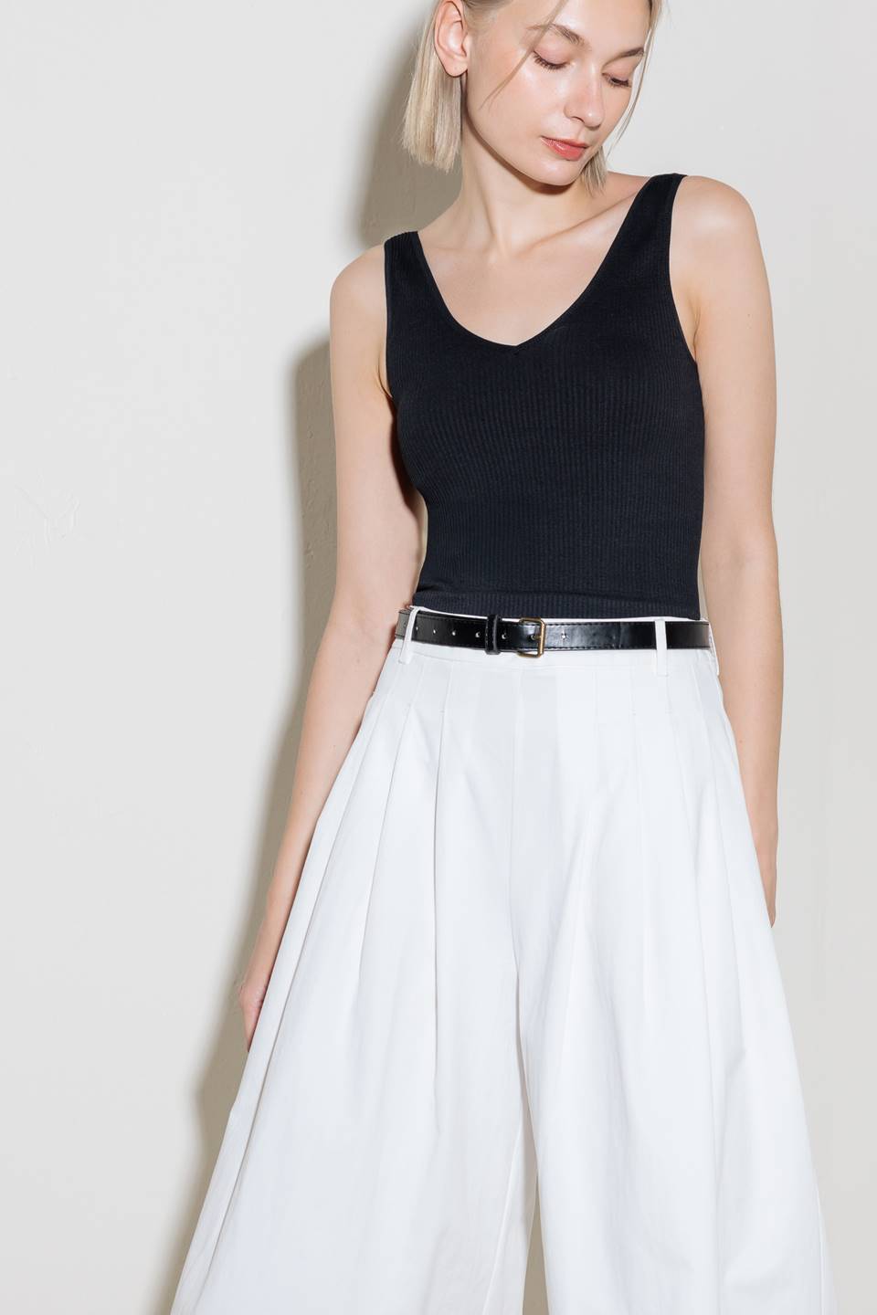 A solid woven culotte pant with front pleat, belt and side zipper closure.