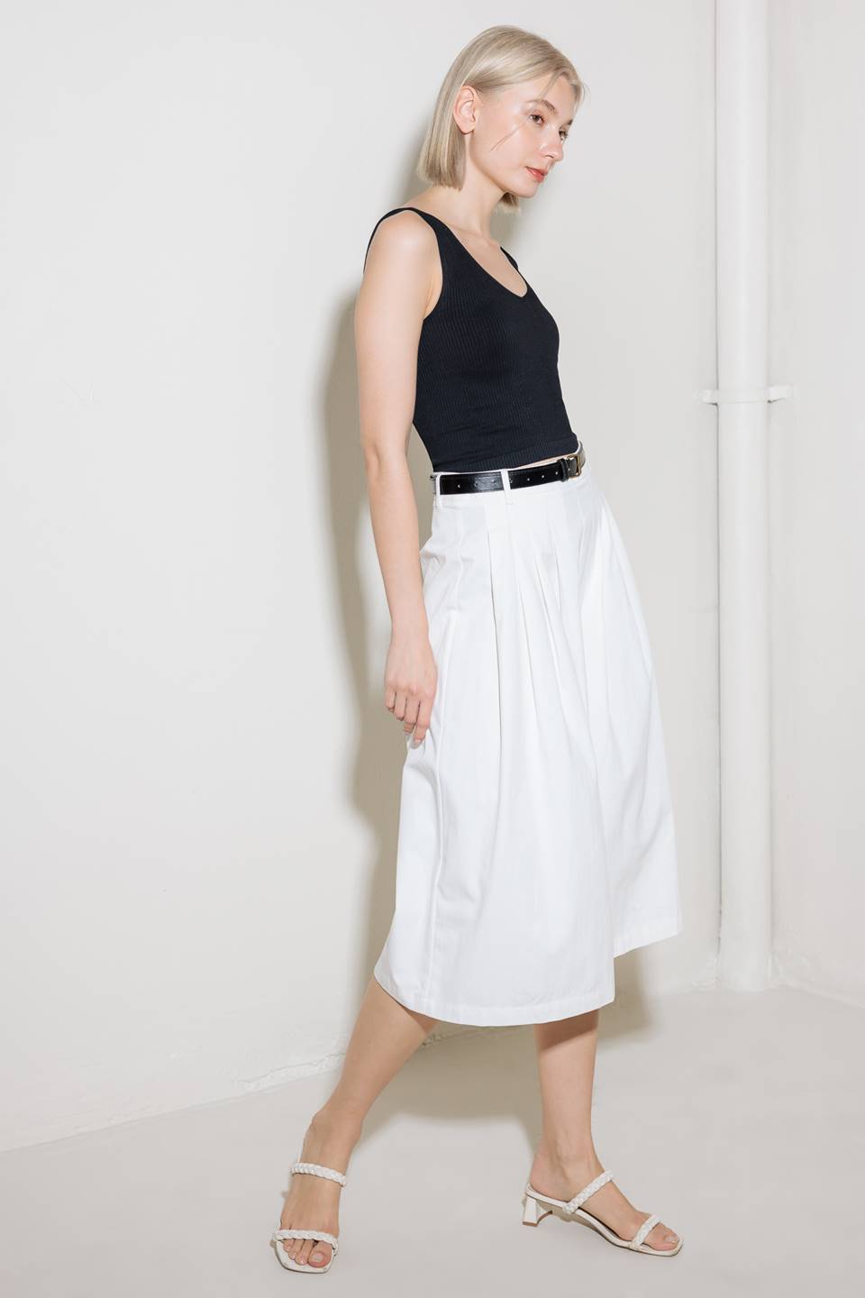 A solid woven culotte pant with front pleat, belt and side zipper closure.