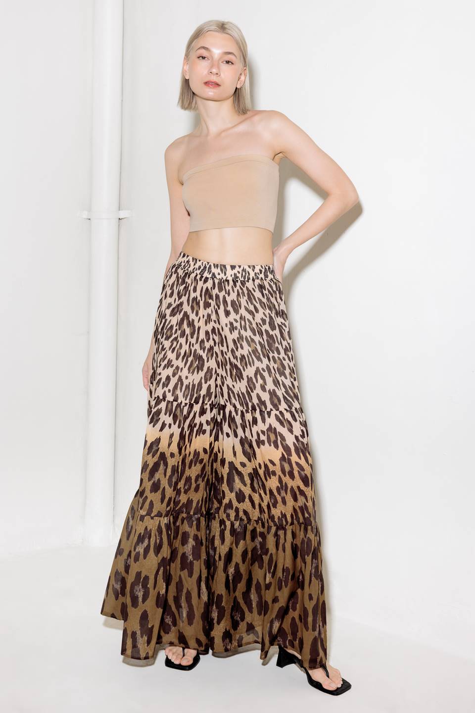 A printed woven pant featuring smocked waistband and tiered bottom with wide leg.
