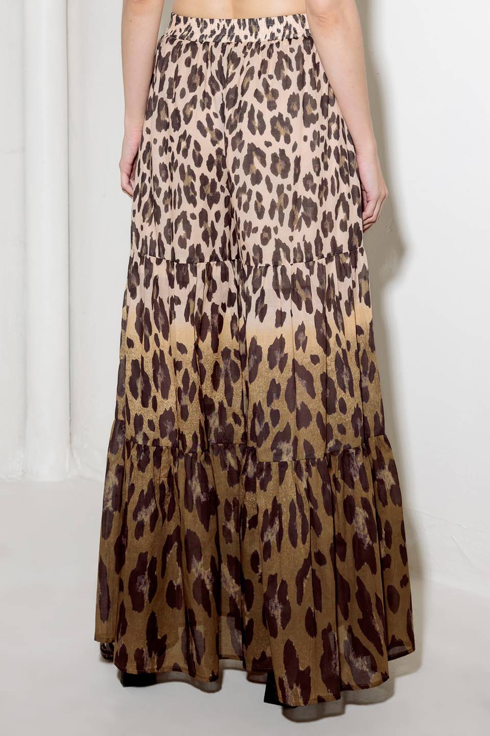 A printed woven pant featuring smocked waistband and tiered bottom with wide leg.