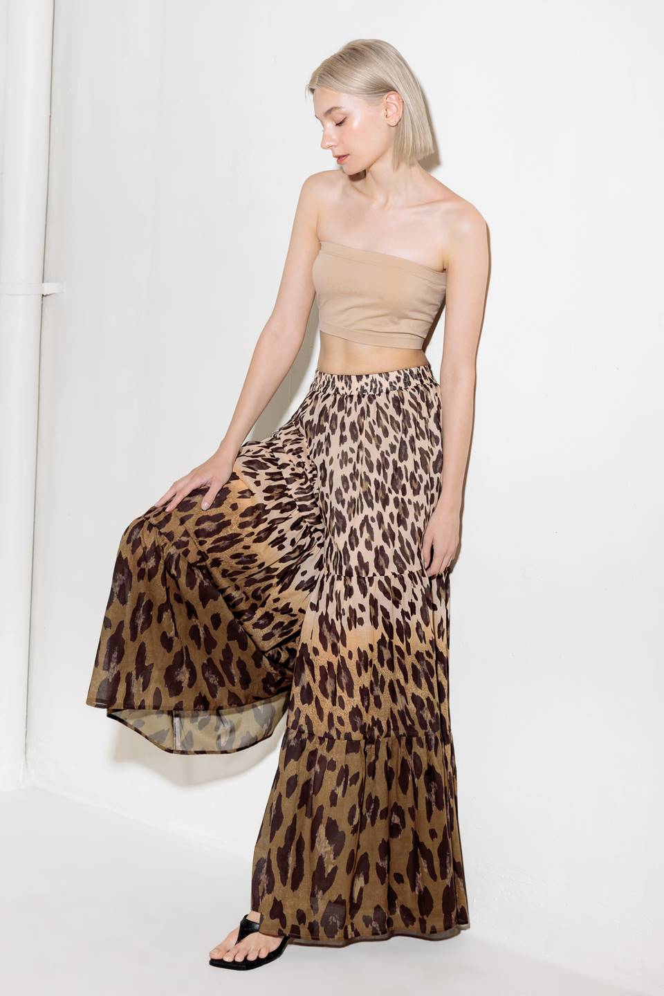 A printed woven pant featuring smocked waistband and tiered bottom with wide leg.
