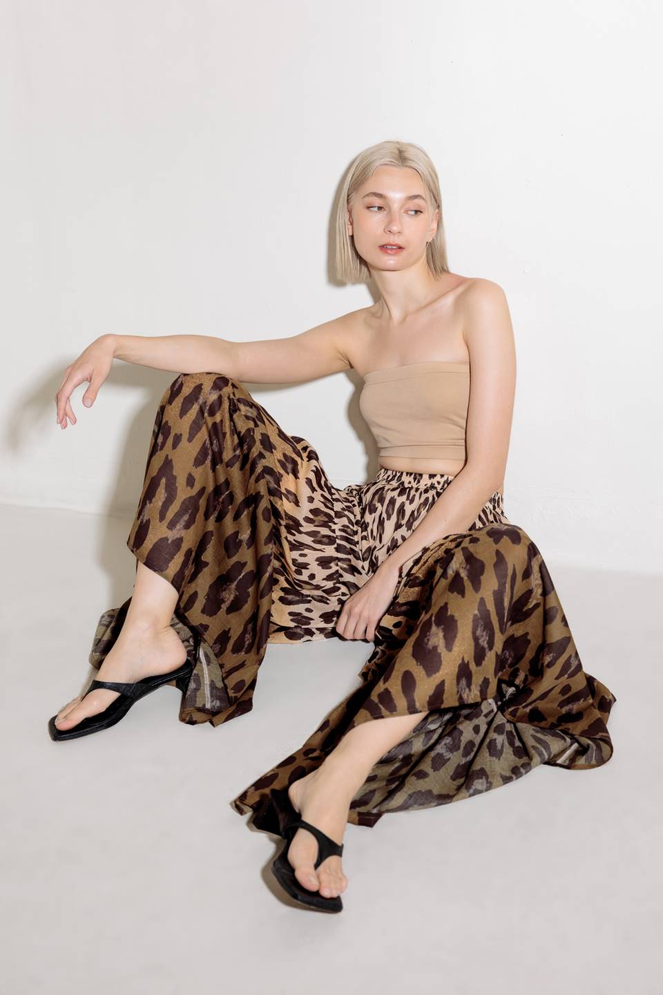 A printed woven pant featuring smocked waistband and tiered bottom with wide leg.