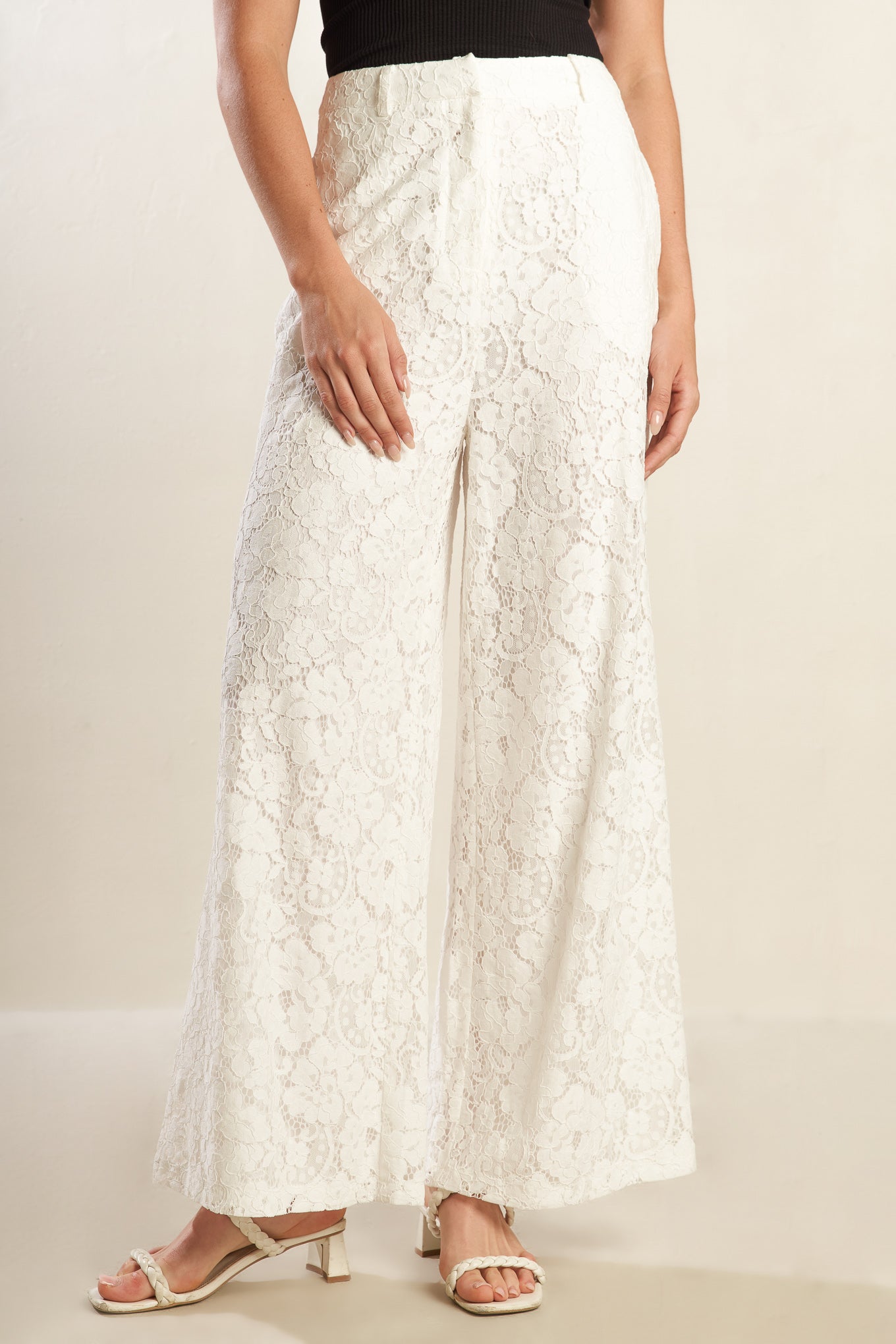 A white woven lace pant featuring side pockets, belt loops, front closure and wide leg.