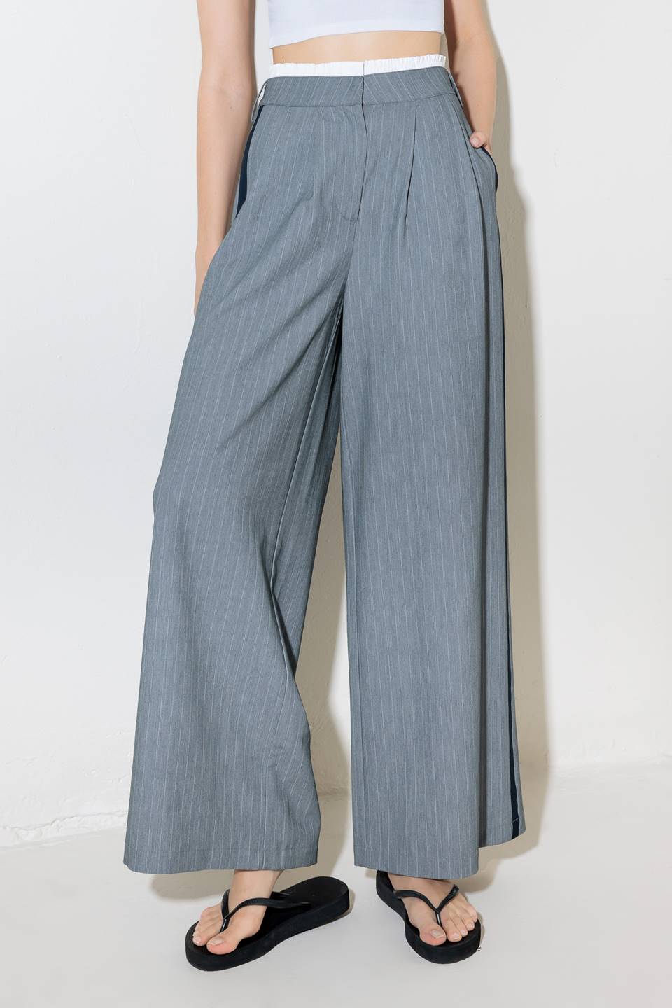 A striped woven pant featuring contrasting edge waist band, front pleat, side pockets, side stripe detail and wide leg.