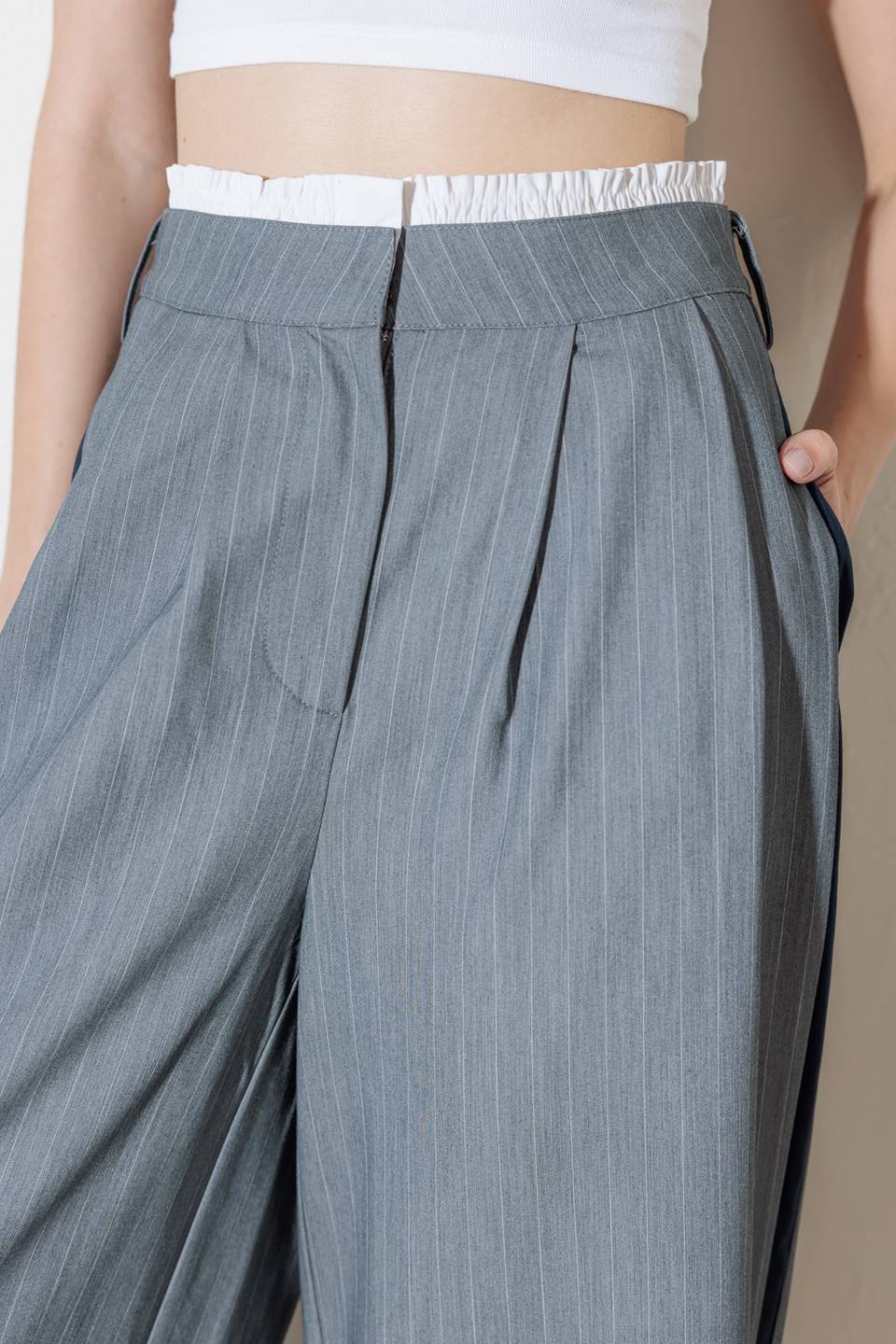 A striped woven pant featuring contrasting edge waist band, front pleat, side pockets, side stripe detail and wide leg.