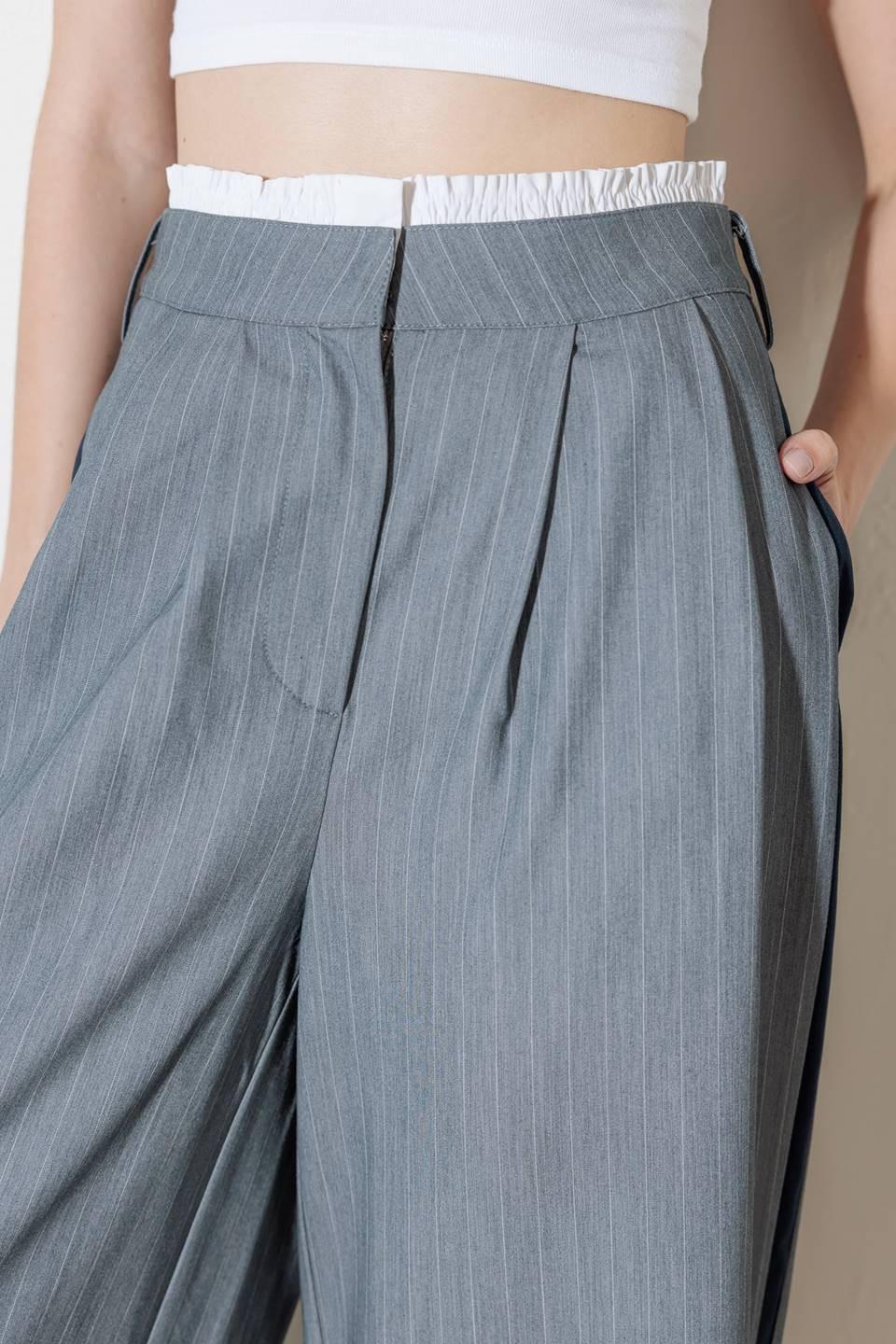 A striped woven pant featuring contrasting edge waist band, front pleat, side pockets, side stripe detail and wide leg.