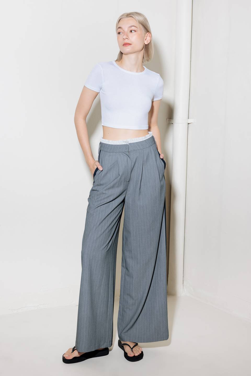 A striped woven pant featuring contrasting edge waist band, front pleat, side pockets, side stripe detail and wide leg.