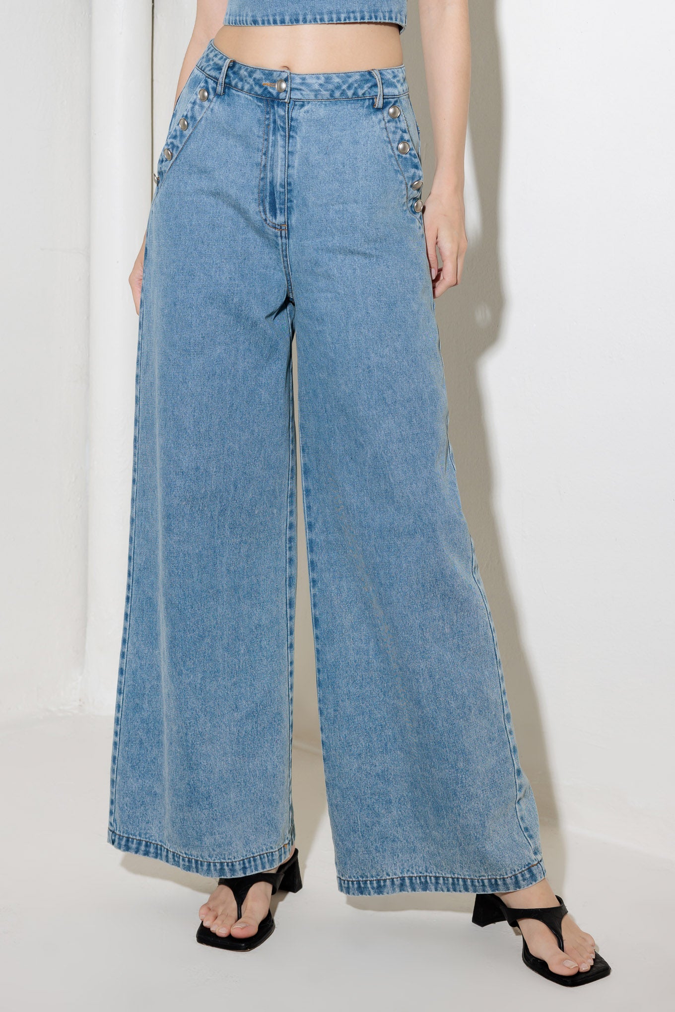 A washed denim pant featuring front closure, side pockets and wide leg.