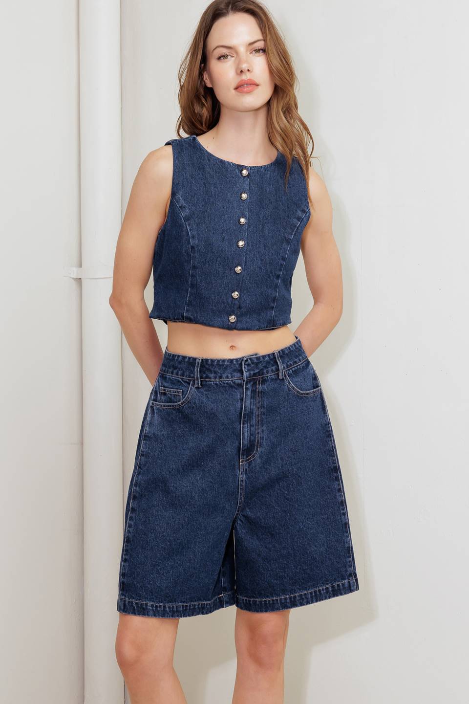 A washed denim short featuring front closure and side/back pockets.