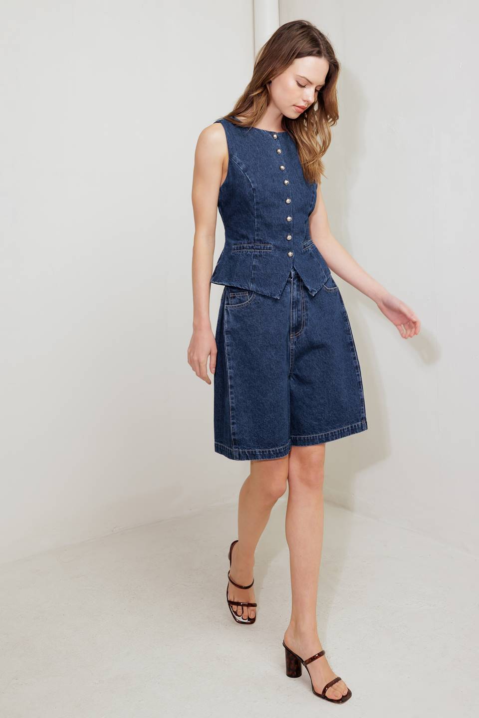 A washed denim short featuring front closure and side/back pockets.