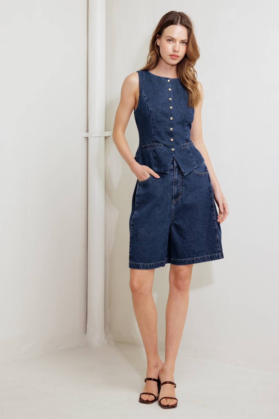 A washed denim short featuring front closure and side/back pockets.