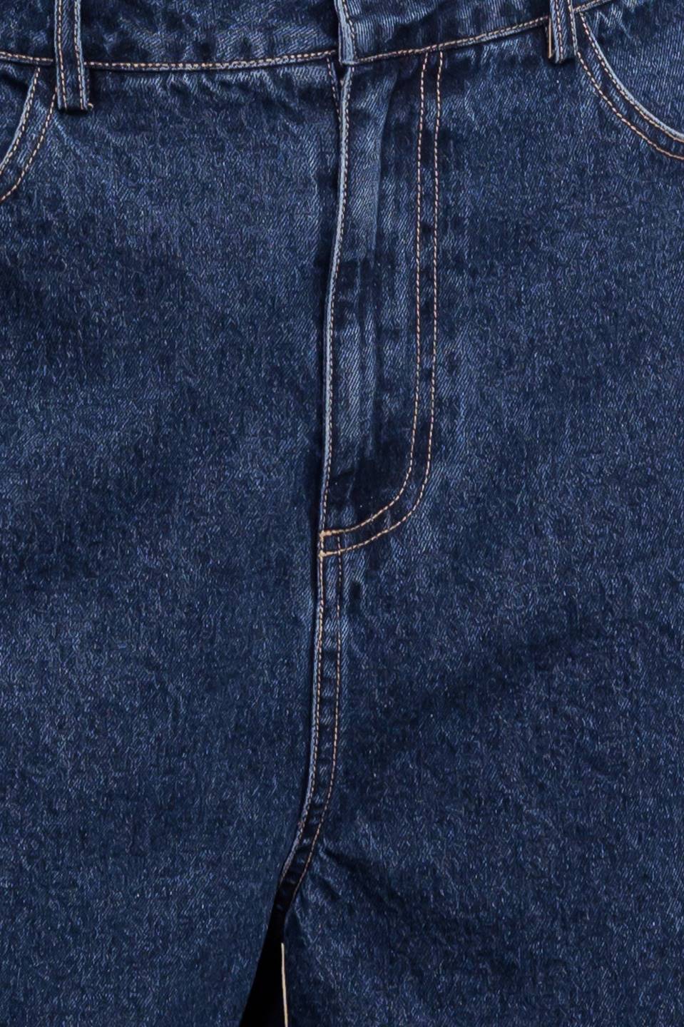A washed denim short featuring front closure and side/back pockets.