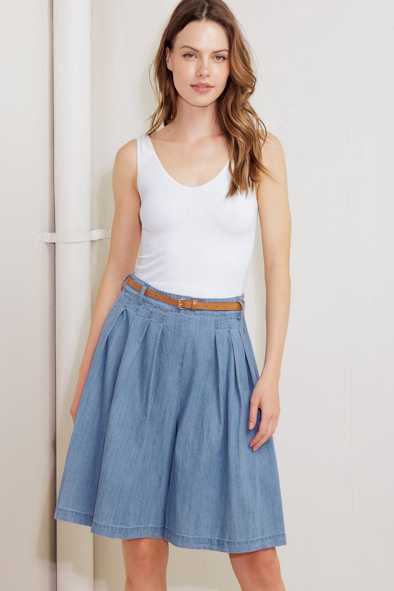 A washed chambray short featuring front pleats, belt, wide leg and side zipper closure.