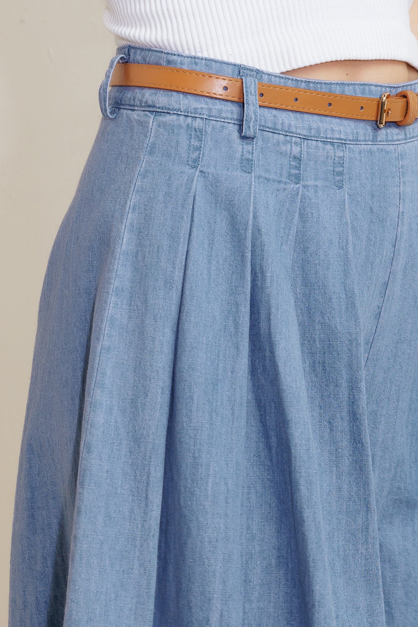 A washed chambray short featuring front pleats, belt, wide leg and side zipper closure.
