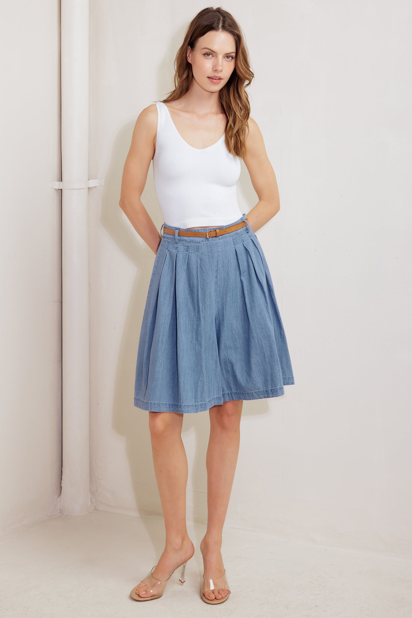 A washed chambray short featuring front pleats, belt, wide leg and side zipper closure.