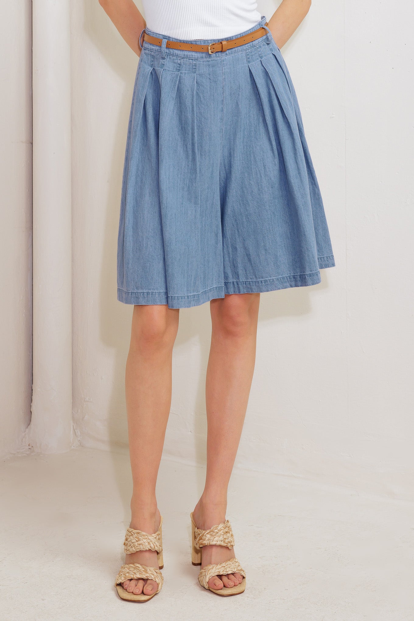 A washed chambray short featuring front pleats, belt, wide leg and side zipper closure.