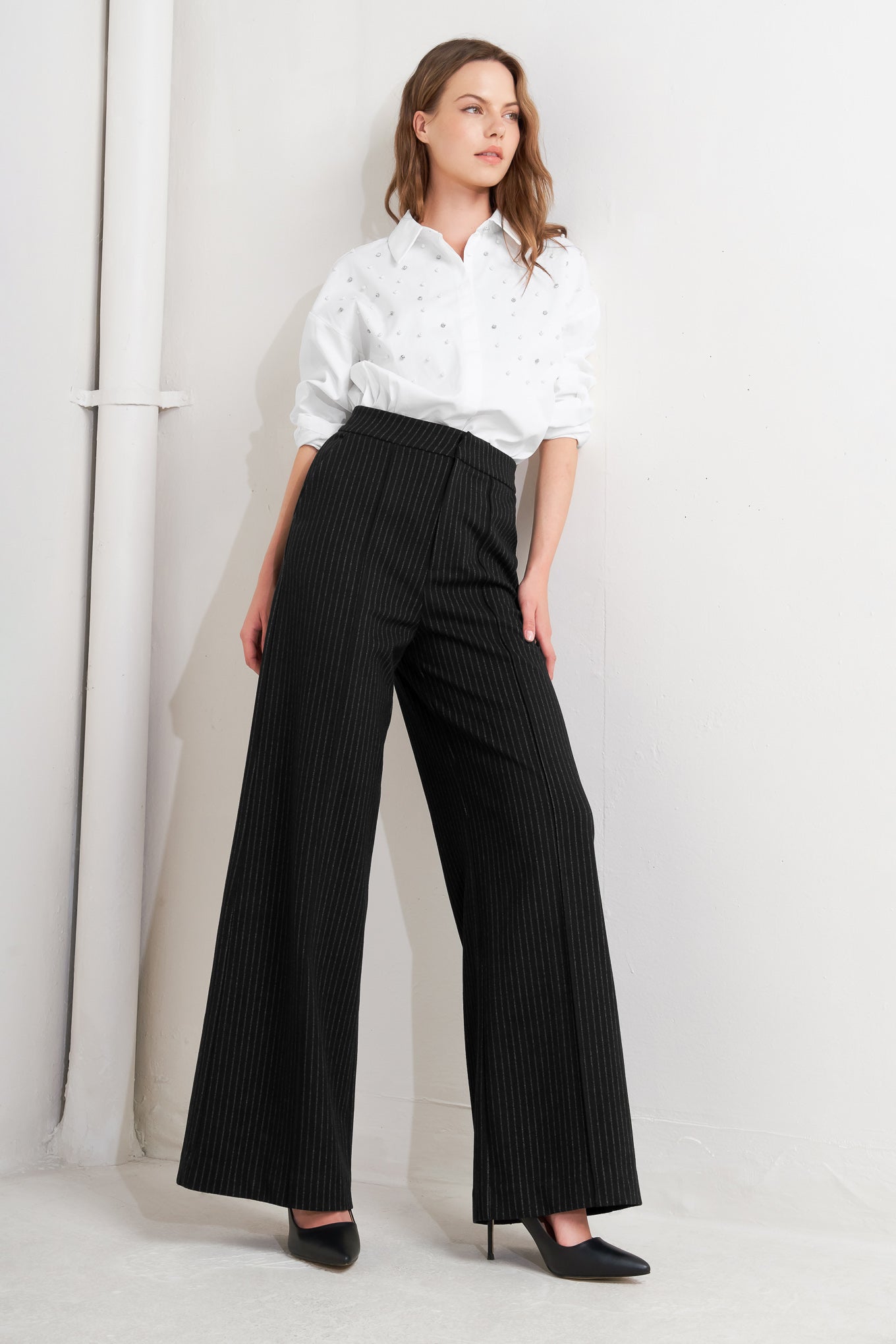 A striped black woven pant with front closure, side pocket and wide leg.