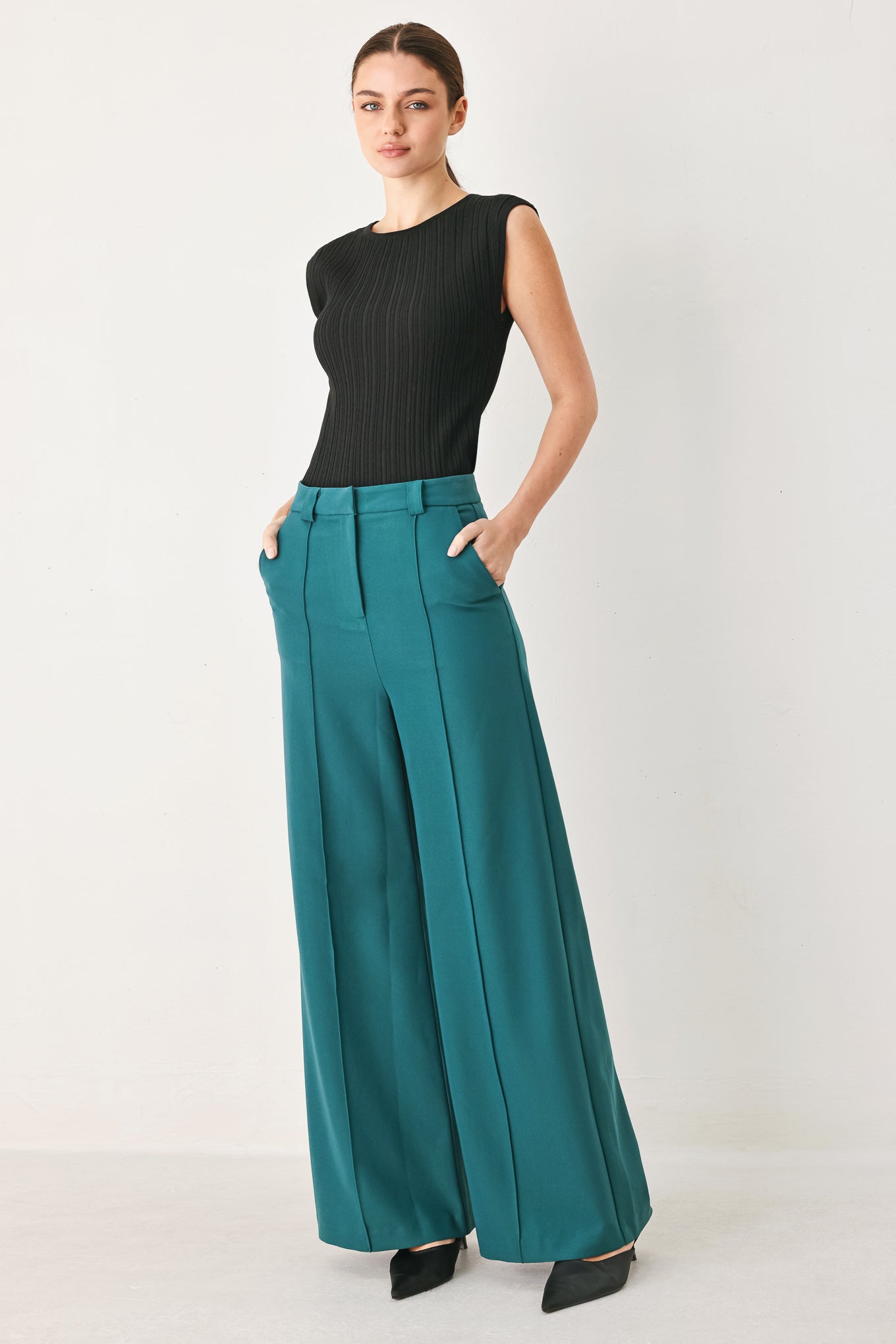 Woman wearing teal woven wide-leg trouser pants with front closure, side pockets | FREEMARKET