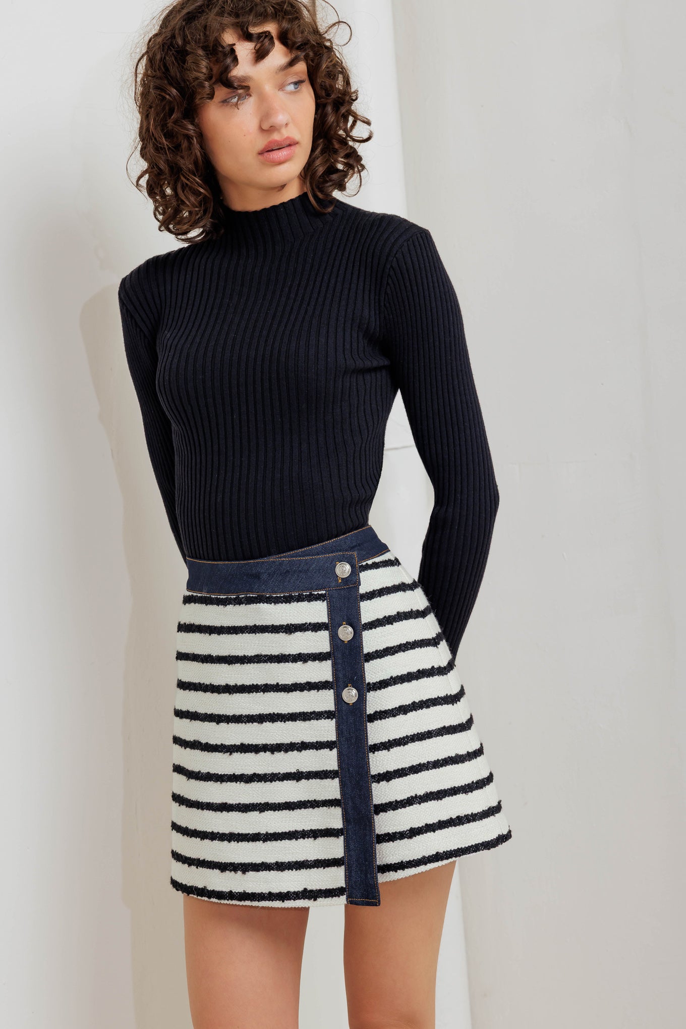 A textured striped woven skort featuring front button detail and denim trimmed edge.